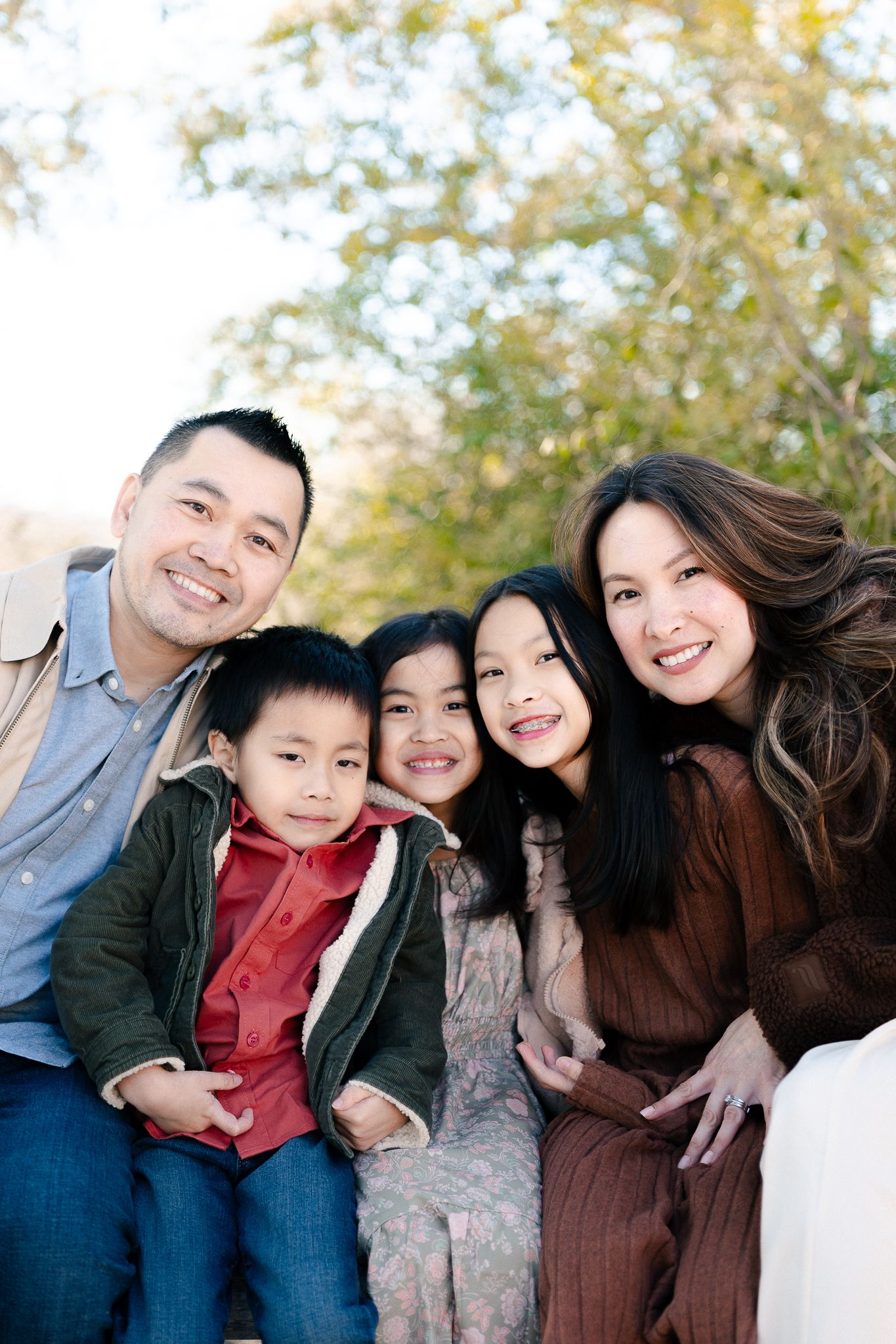 A series of four candid outdoor family photos showing joyful expressions and natural interactions in autumn lighting.