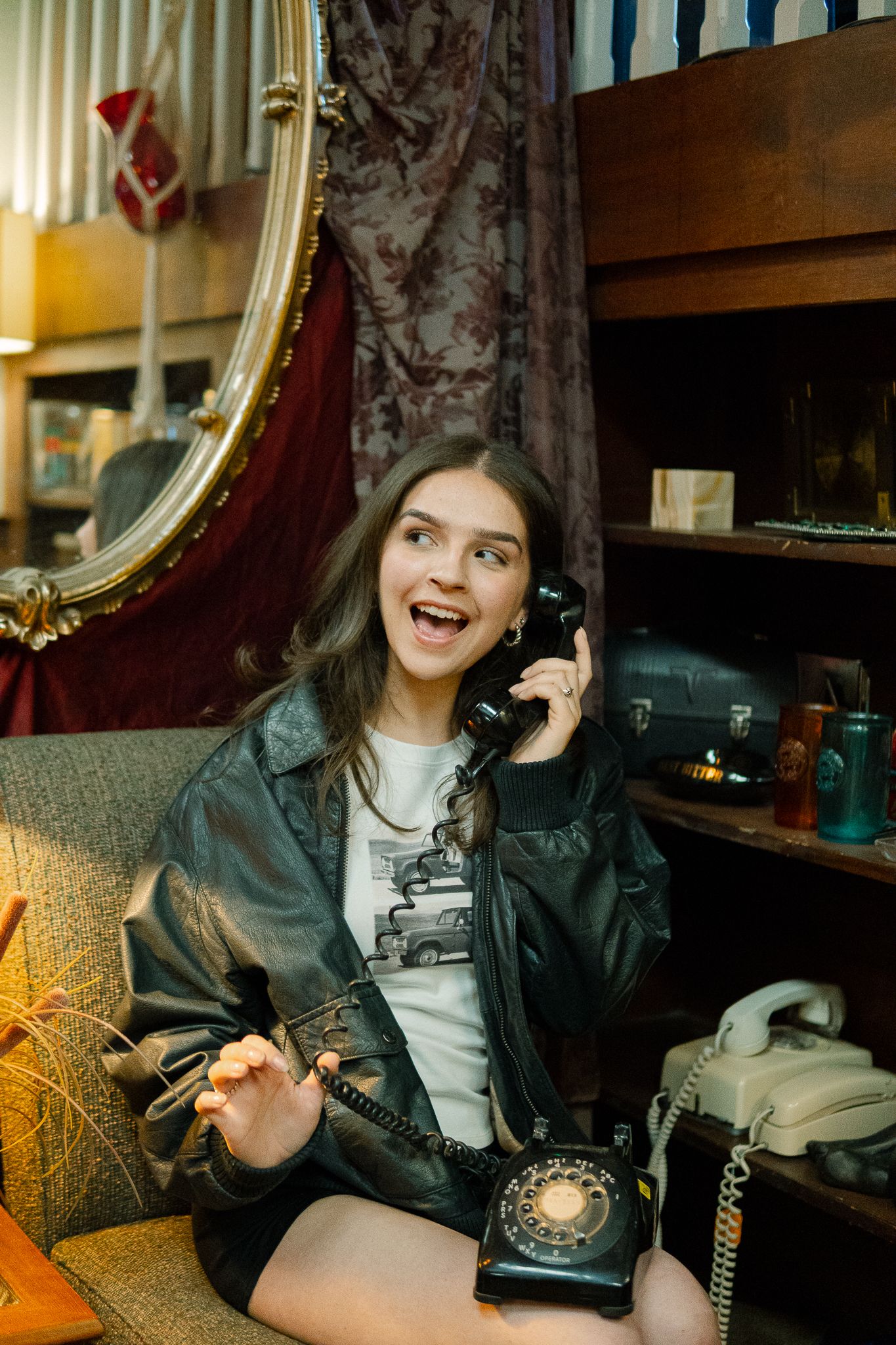 Four sequential photos show someone in a leather jacket using a vintage rotary telephone while sitting on a patterned couch.