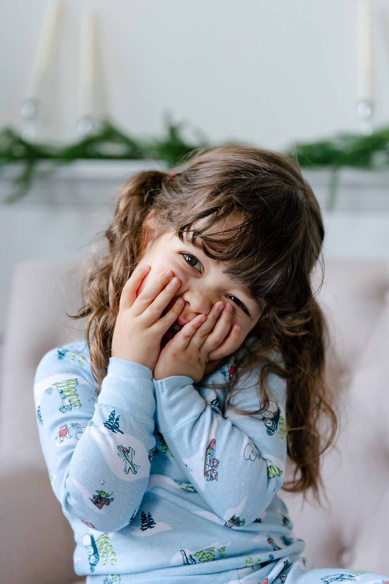 Child in blue patterned pajamas playfully covering face with hands in a series of candid shots.
