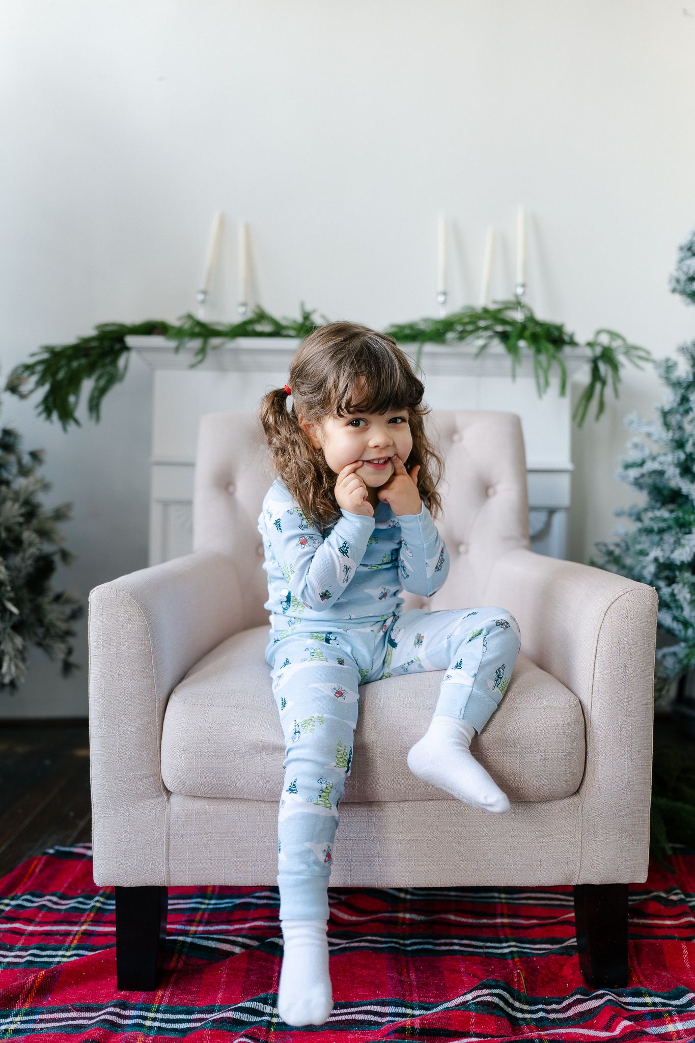 Series of candid shots on a beige couch with red plaid rug showing playful poses in blue sleepwear.