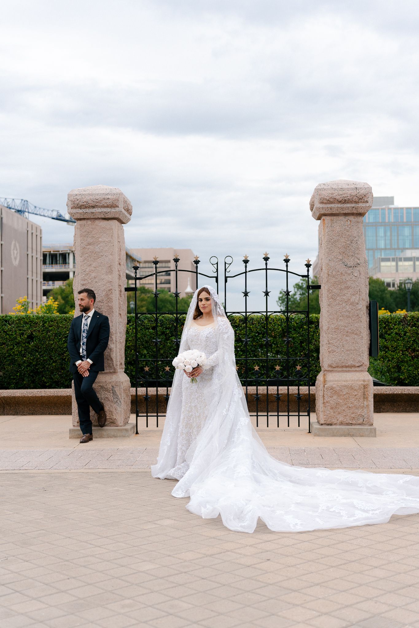 A romantic wedding photo sequence showing a bride and groom posing between stone pillars on an outdoor terrace.