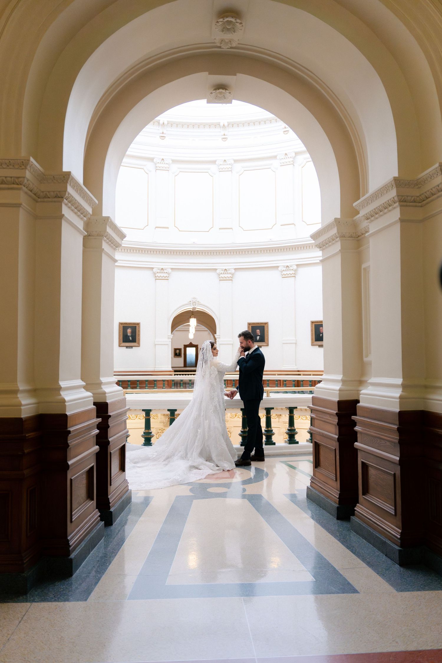 A series of four elegant archway photos showing a wedding couple in a grand white hallway with marble columns and floors.