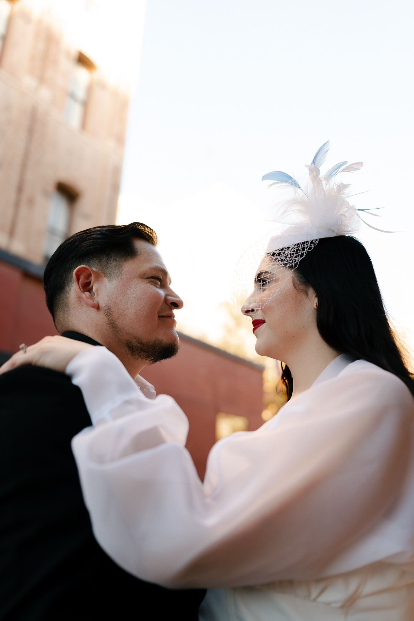 A couple in white embraces and dances together in a romantic sequence of photos at sunset.