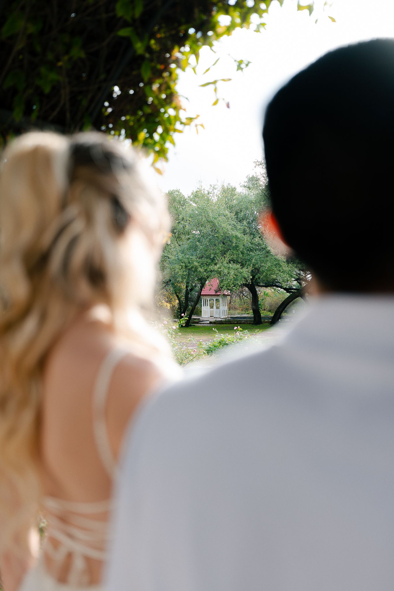 A series of four wedding photos showing the couple in an outdoor garden setting with soft bokeh lighting effects.