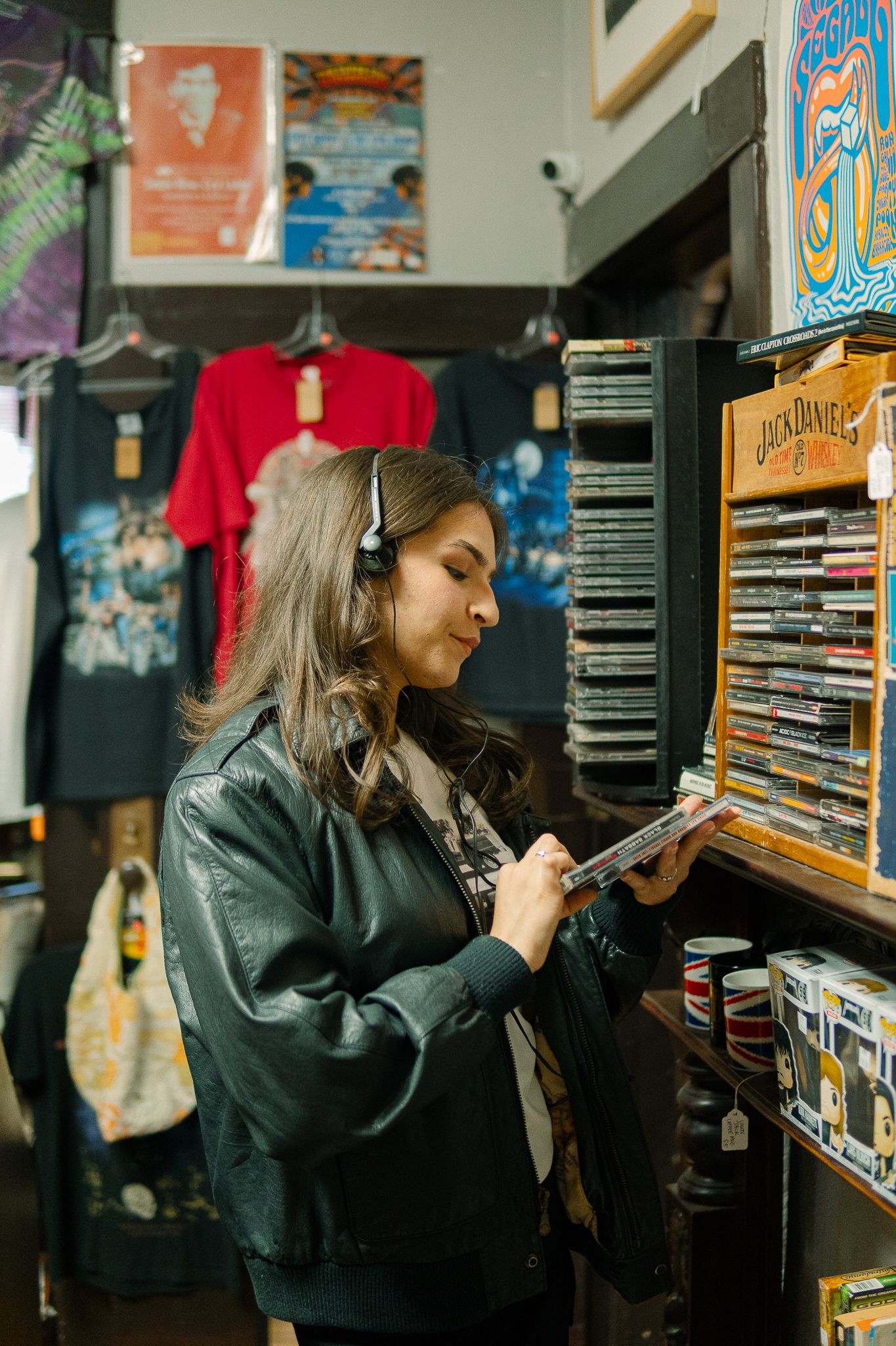 Someone browses through a collection of video games or DVDs on shelves in a dark room.