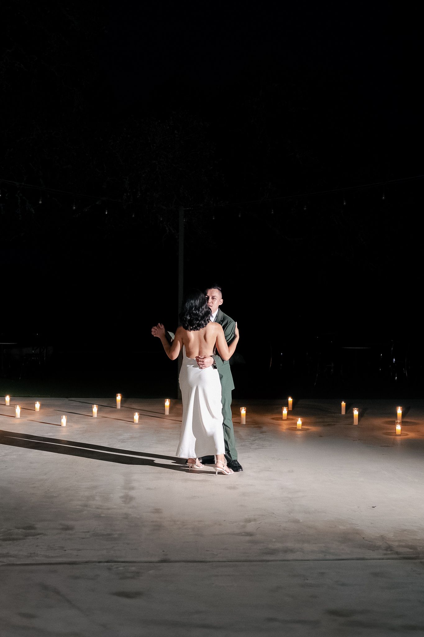 Five sequential photos show a dance performance on a dark stage illuminated by candlelight with dancers in white costumes.