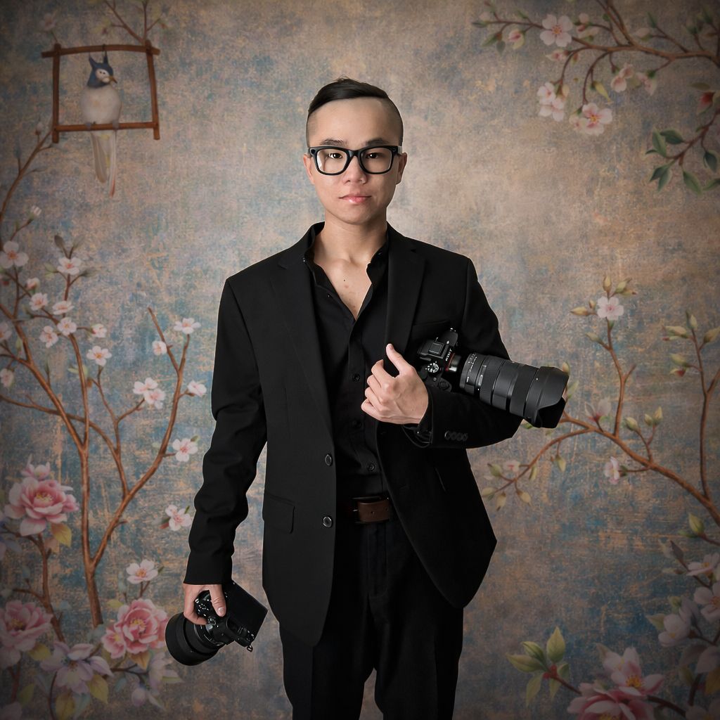 Professional photographer in all black attire poses with camera against floral backdrop in three artistic shots.