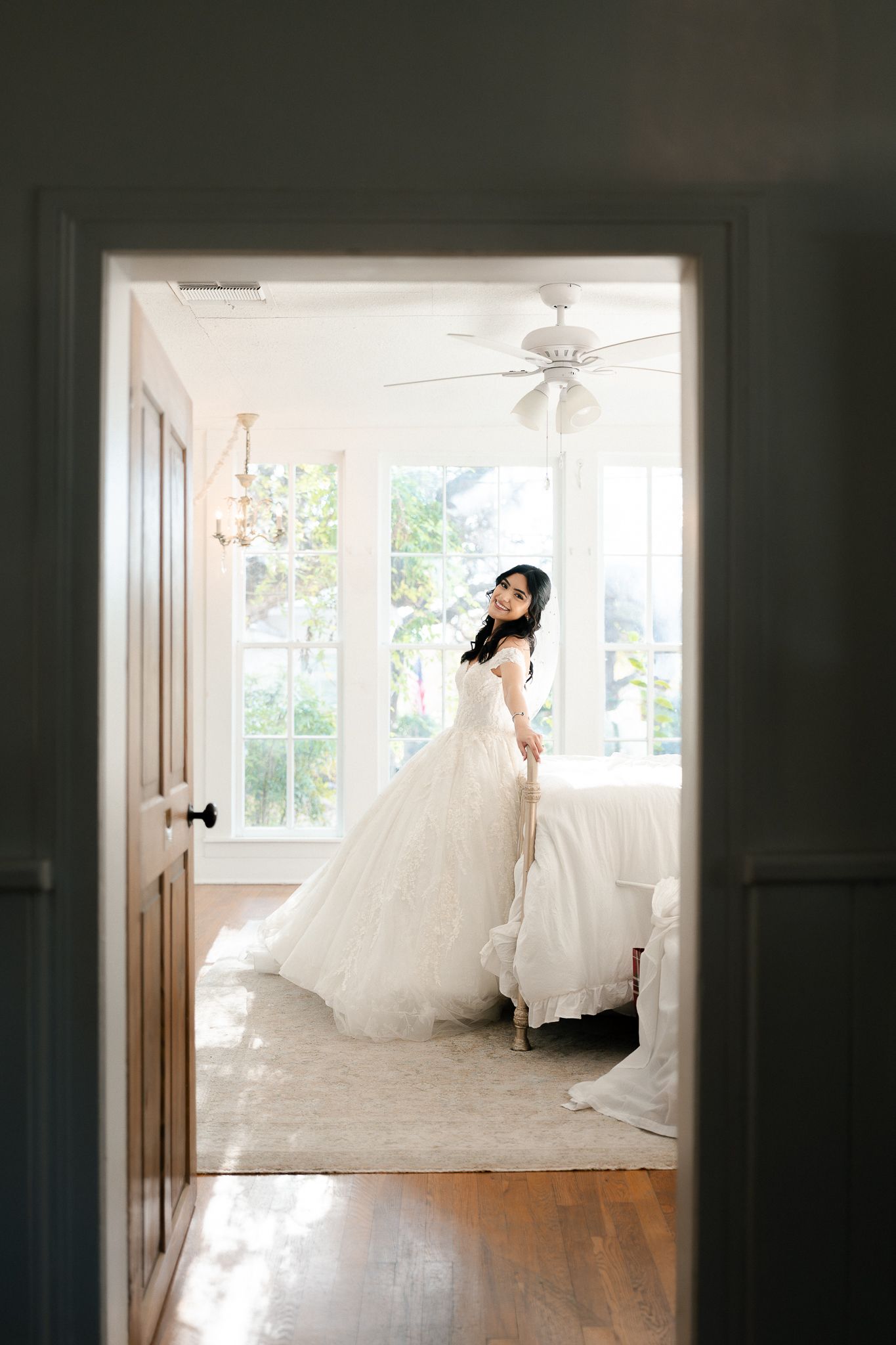 A sequence of elegant wedding dress photos showing flowing white gowns in a bright sunlit room with hardwood floors.