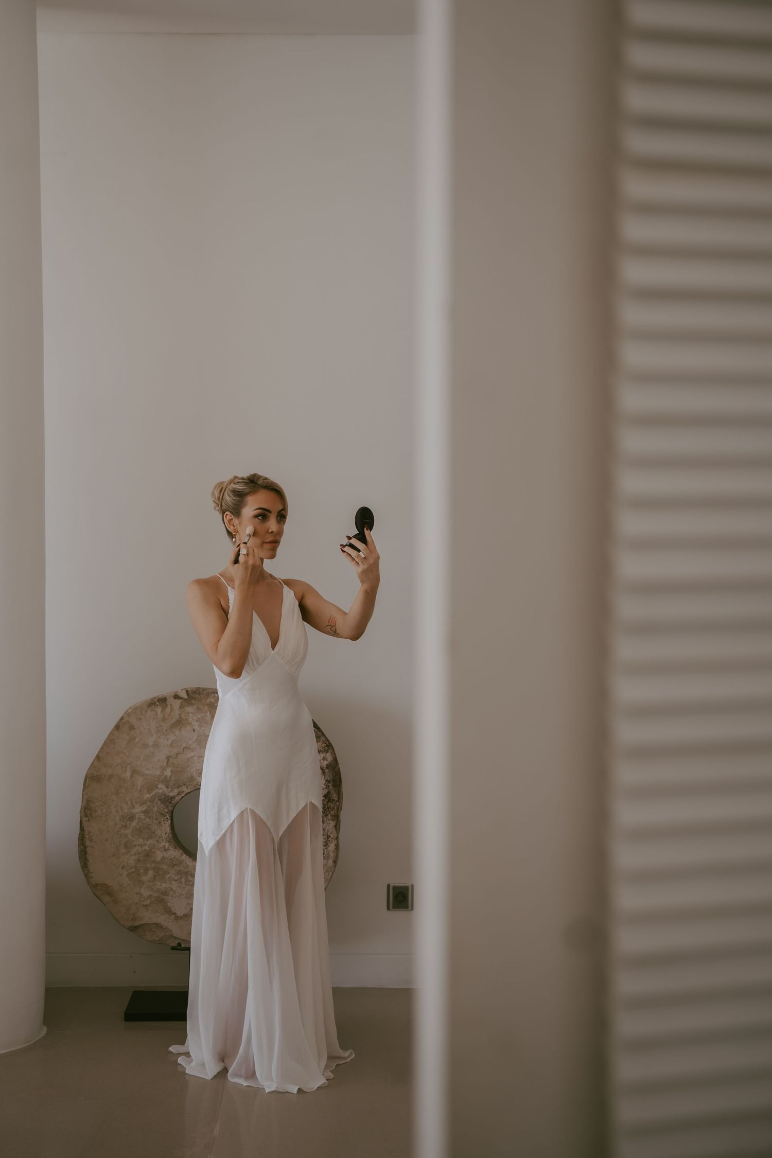 White-dressed figures pose playfully in an indoor setting with natural light.