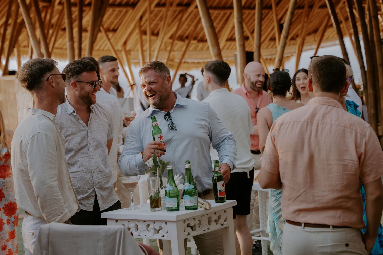 Wedding guests dance and celebrate on a rustic wooden dance floor at an evening reception.