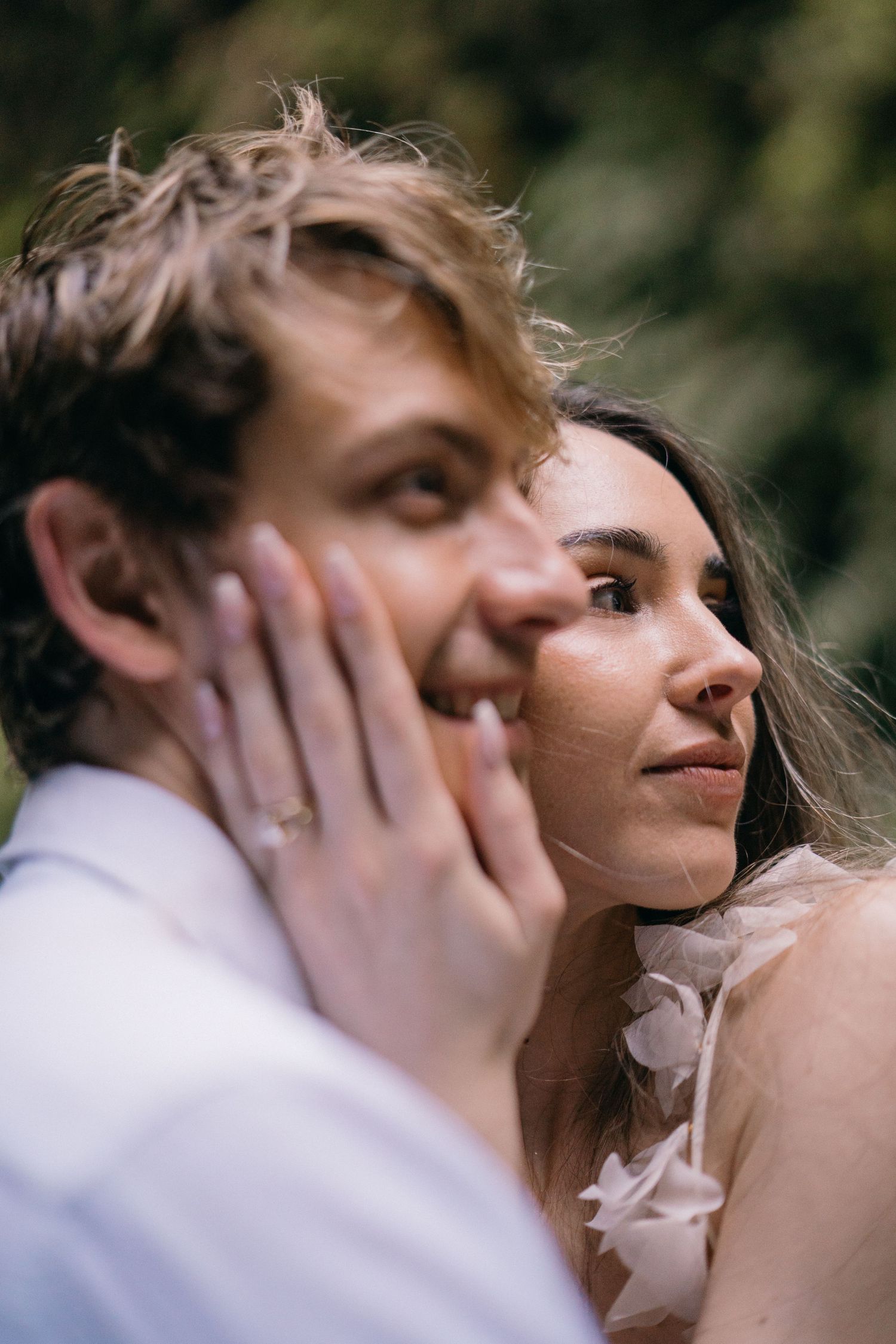 A tender romantic moment captured in soft focus as a couple shares an intimate embrace outdoors.