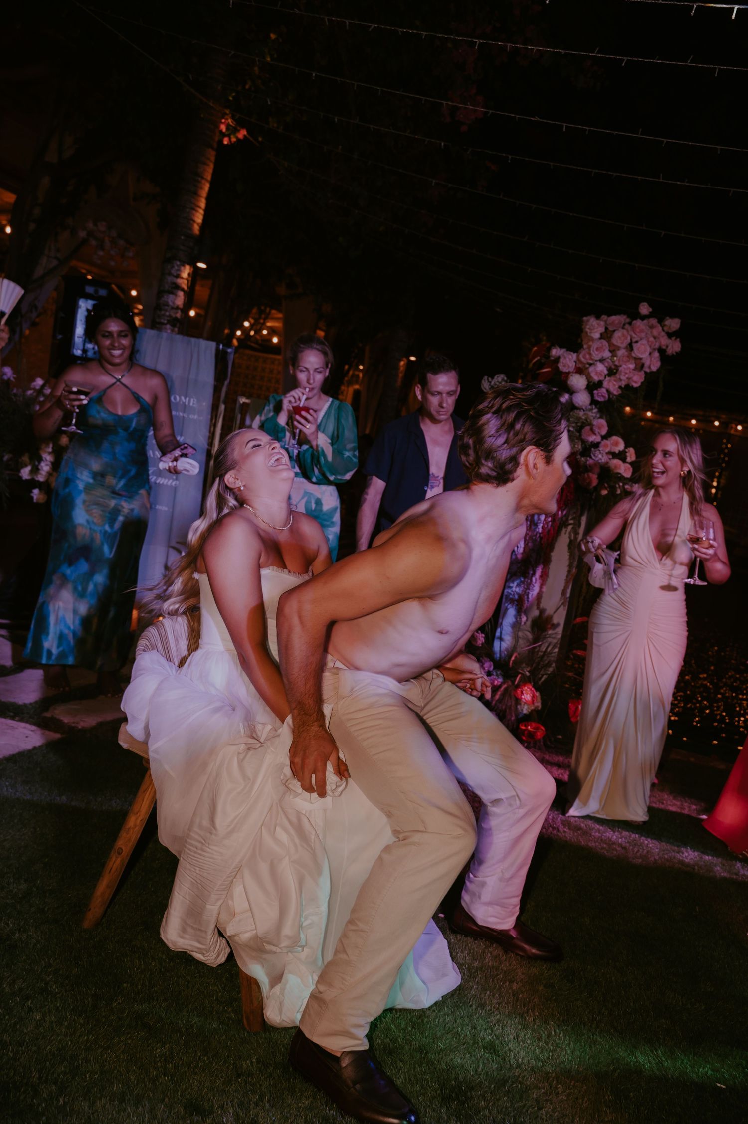 Bride and groom share an energetic dance together at their outdoor evening wedding reception.