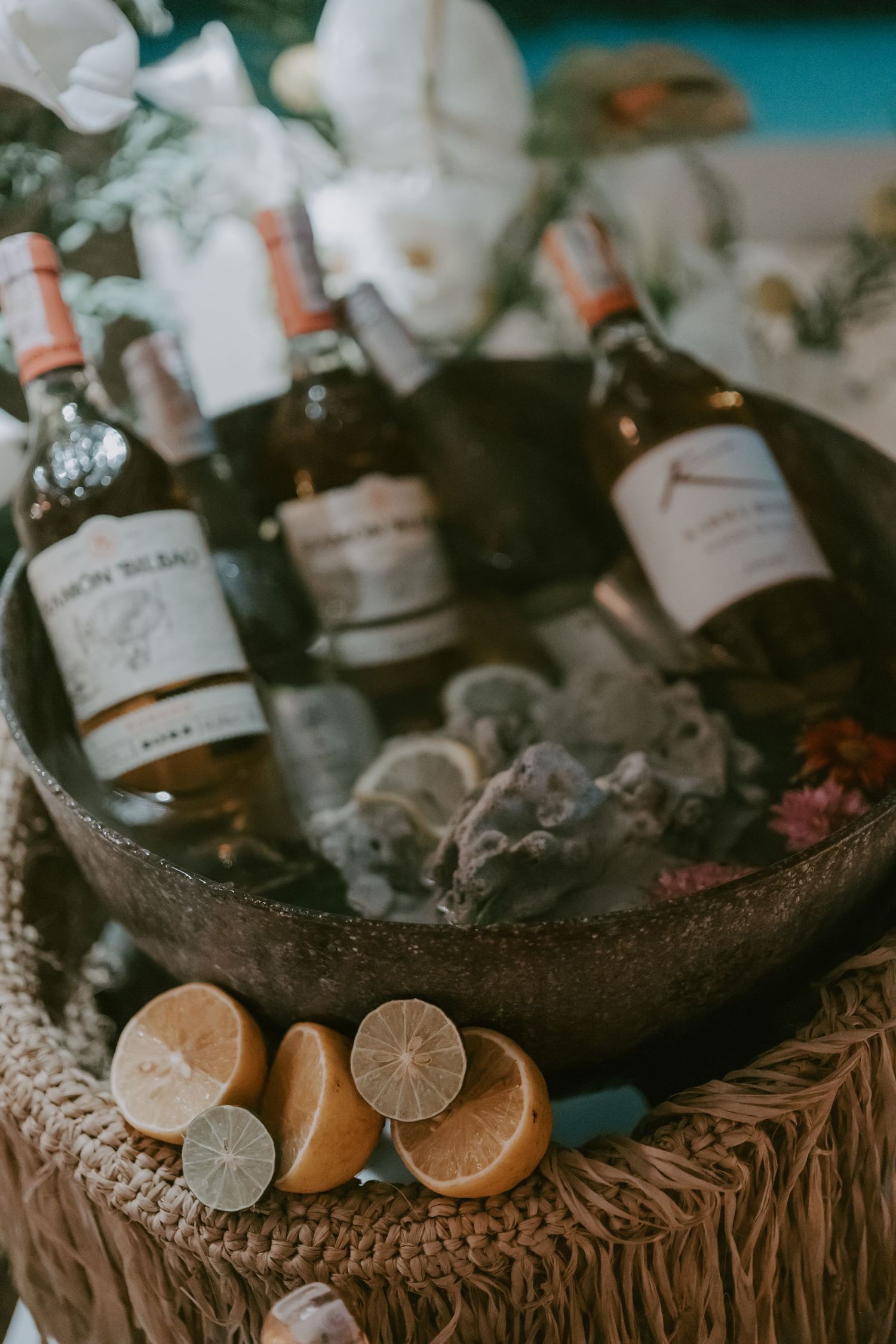 Rustic bar setup with citrus garnishes and bottles in woven basket.