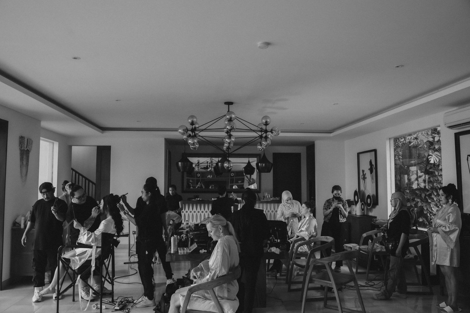 Black and white panoramic shot of people gathering in a spacious indoor venue.