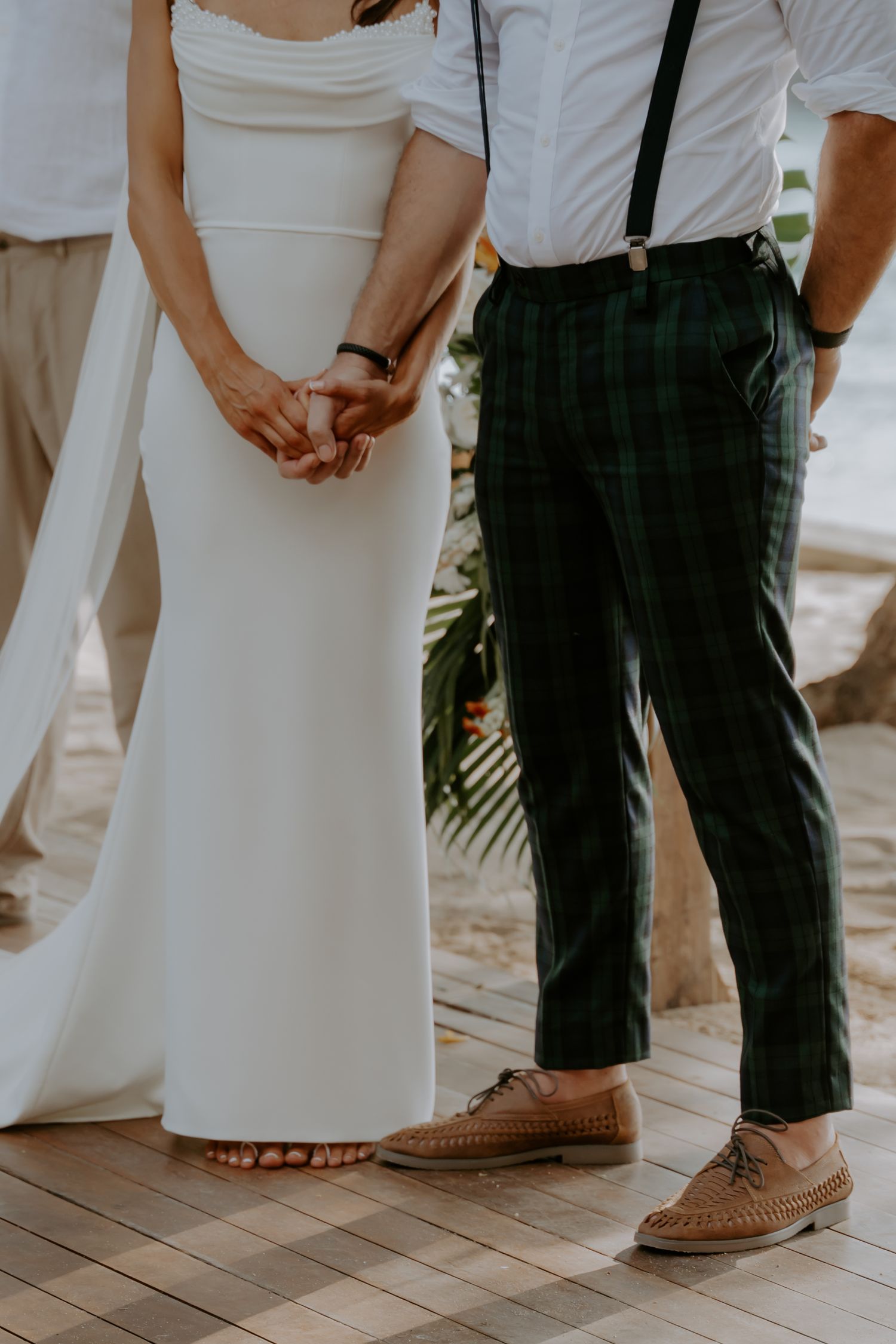 Close-up view of brown leather loafers and formal attire at an elegant event on wooden flooring.