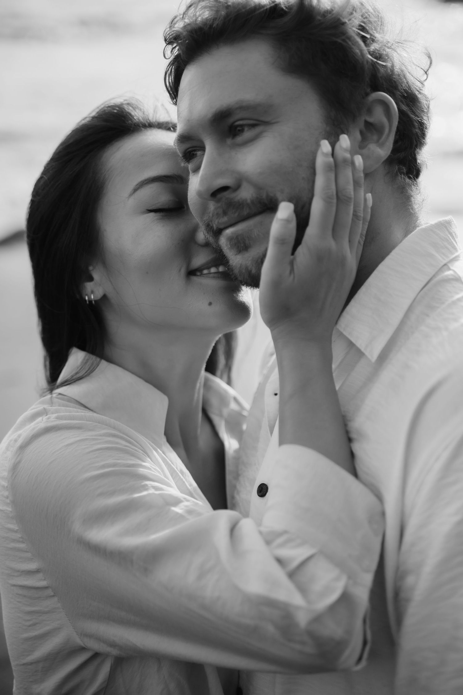 A romantic black and white photo sequence showing a couple in white shirts sharing tender moments and kisses.
