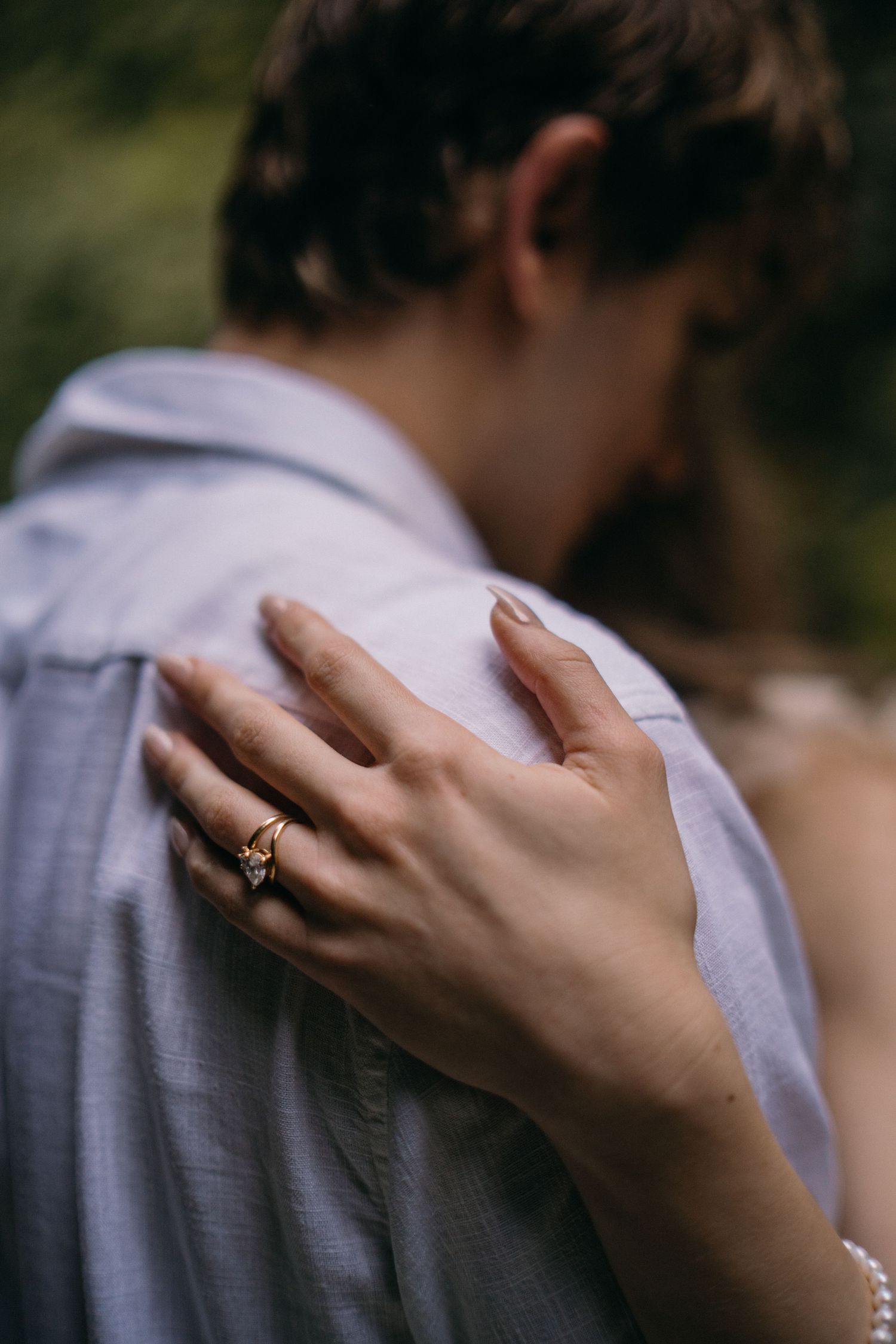 A series of close-up shots showing a hand gently caressing a person's shoulder in a white shirt.