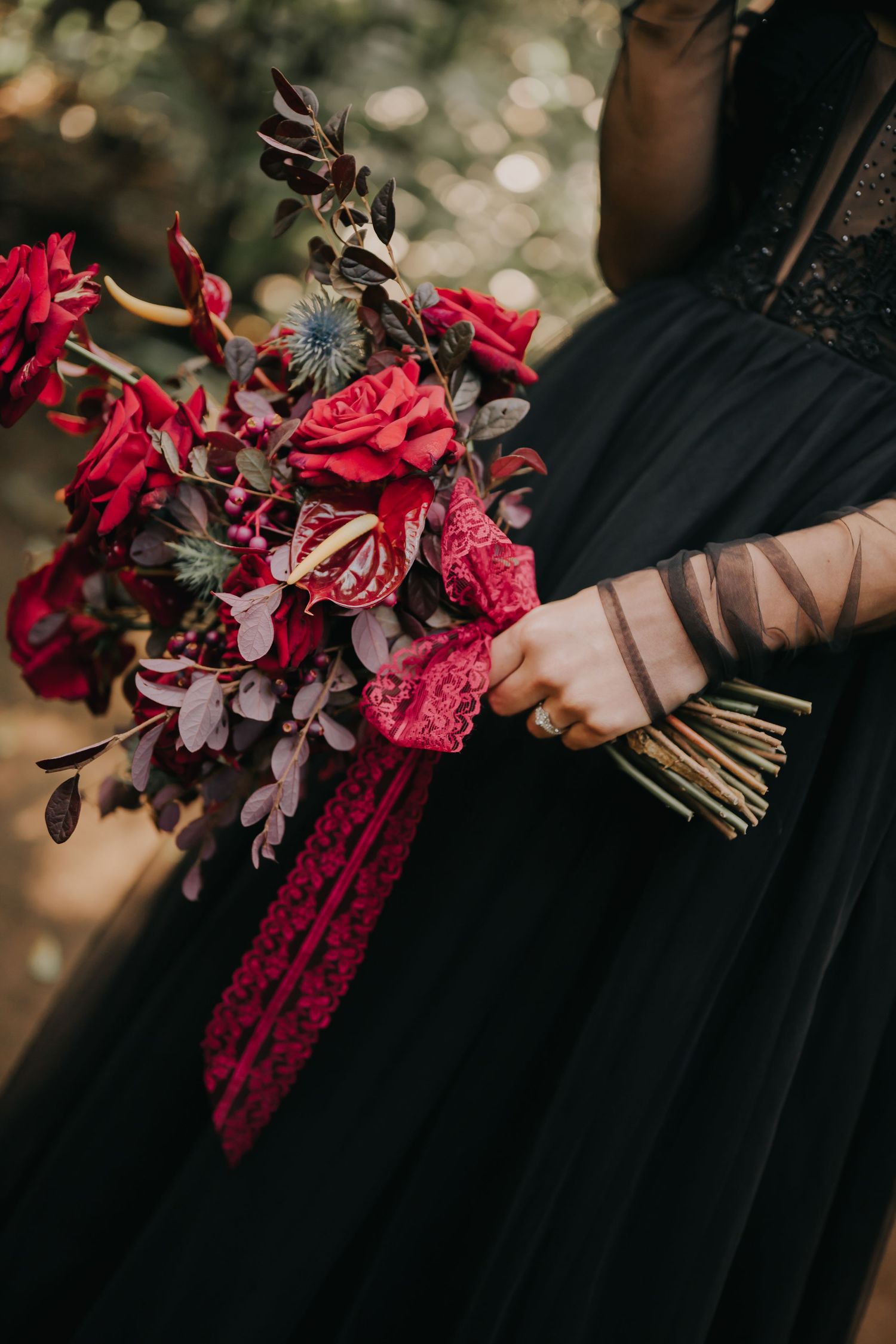 Deep red and burgundy floral bouquet details against black formal dress.