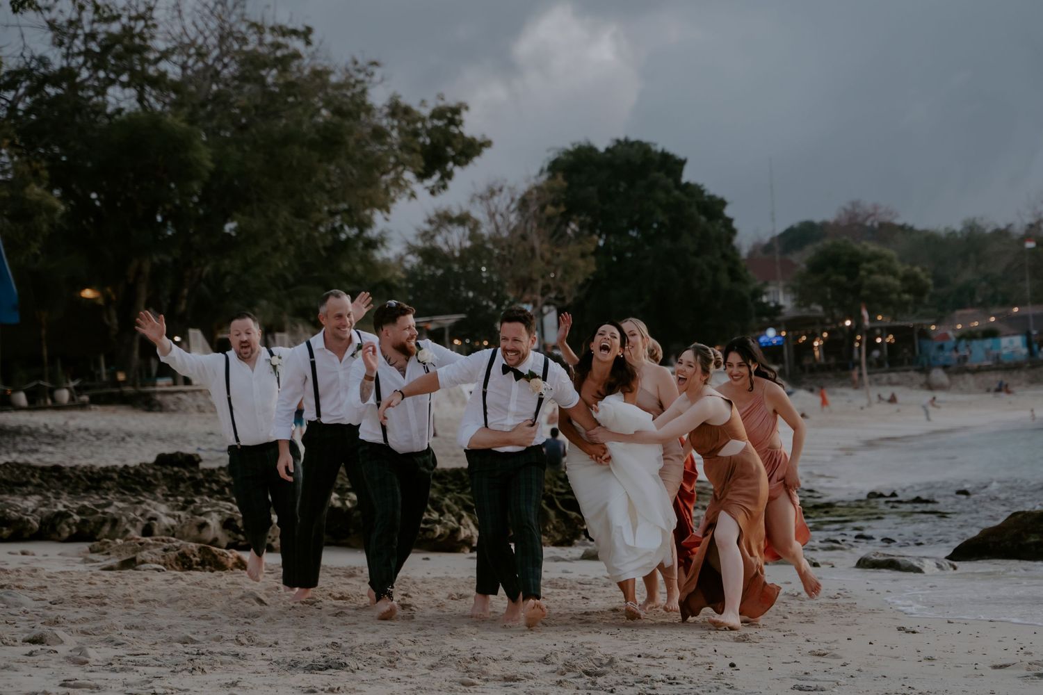 A series of beach wedding photos showing people gathering on a tropical shoreline during a sunset ceremony.