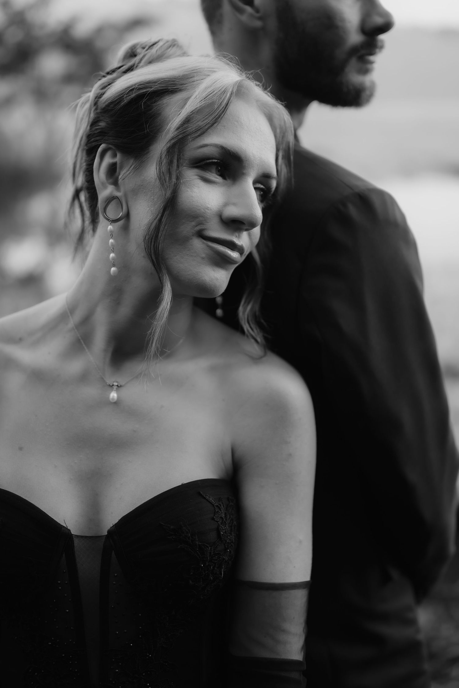 Black and white close-up portrait shots of a couple in formal attire sharing intimate moments.