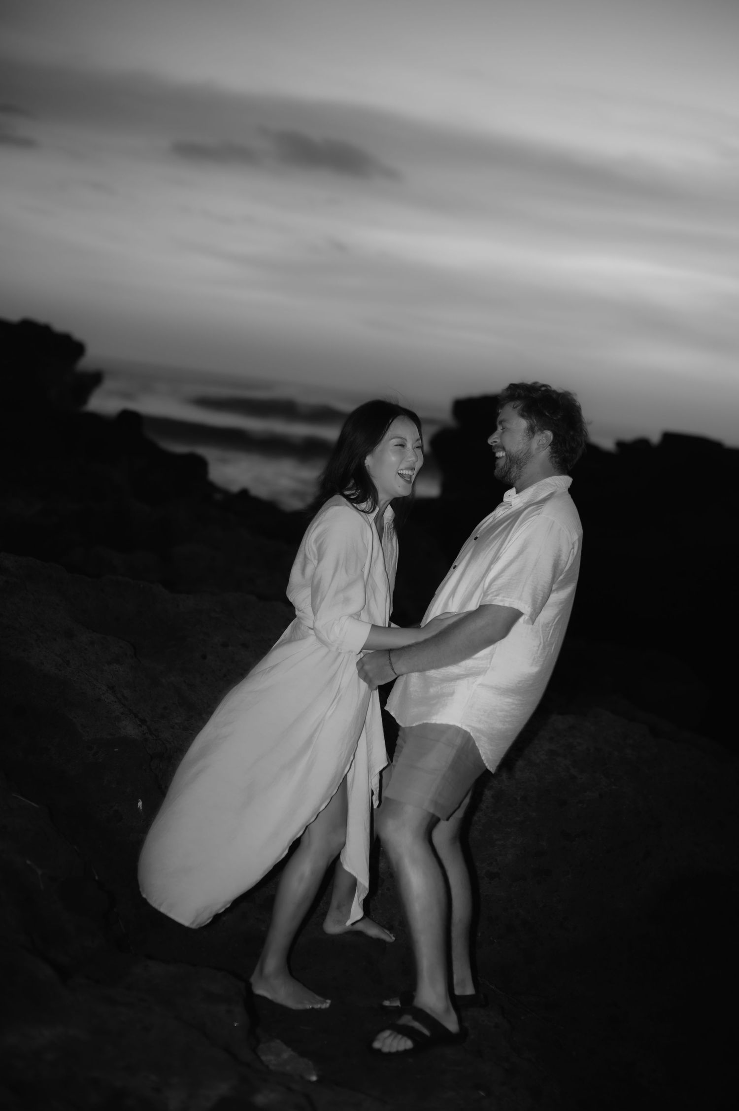 A playful black and white photo sequence shows a couple dancing and spinning together outdoors at dusk.