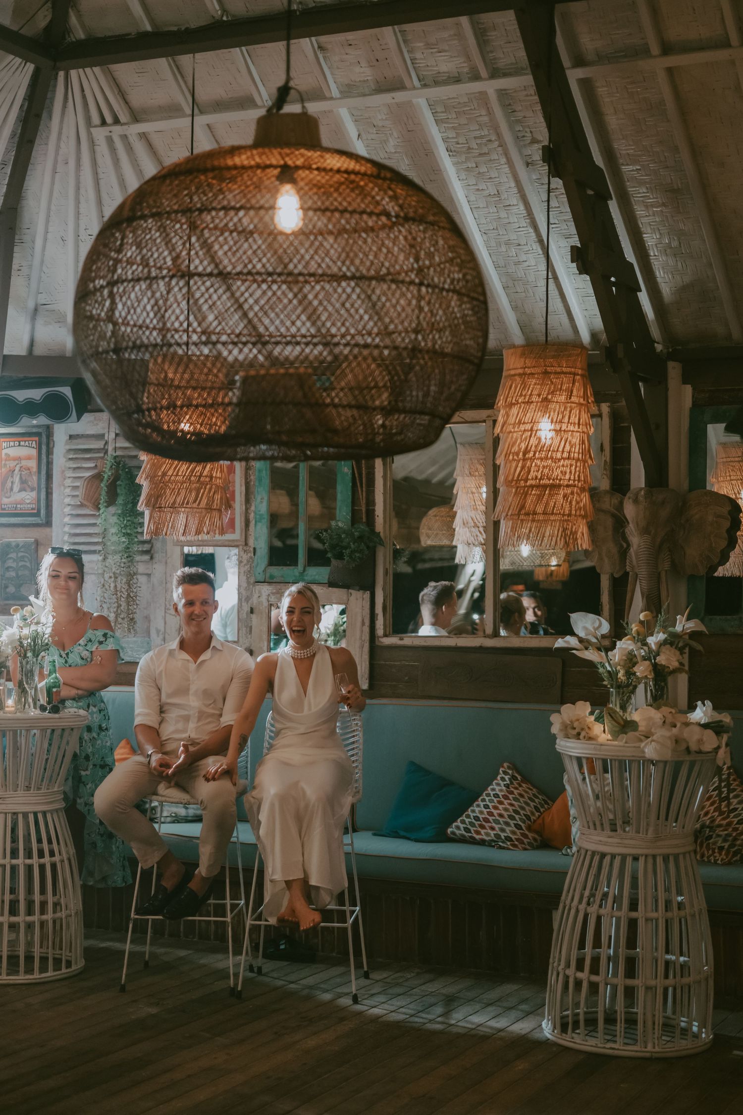 Tropical-themed venue with large woven pendant lights and coastal decor.