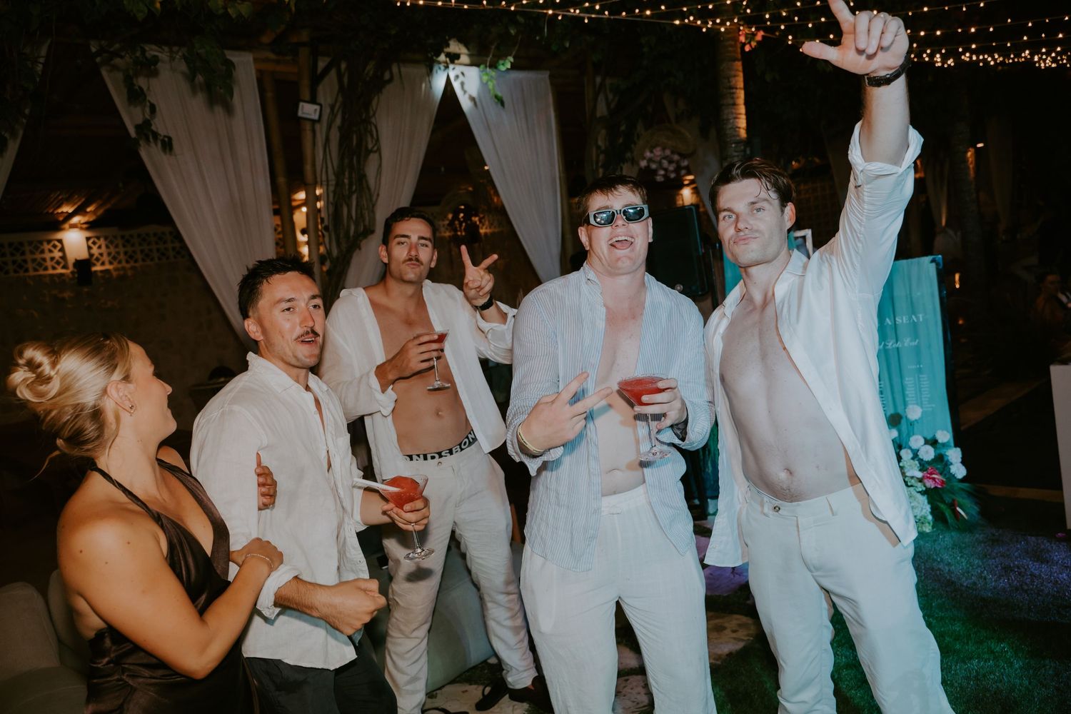 Wedding guests dancing and celebrating at an outdoor evening reception party.