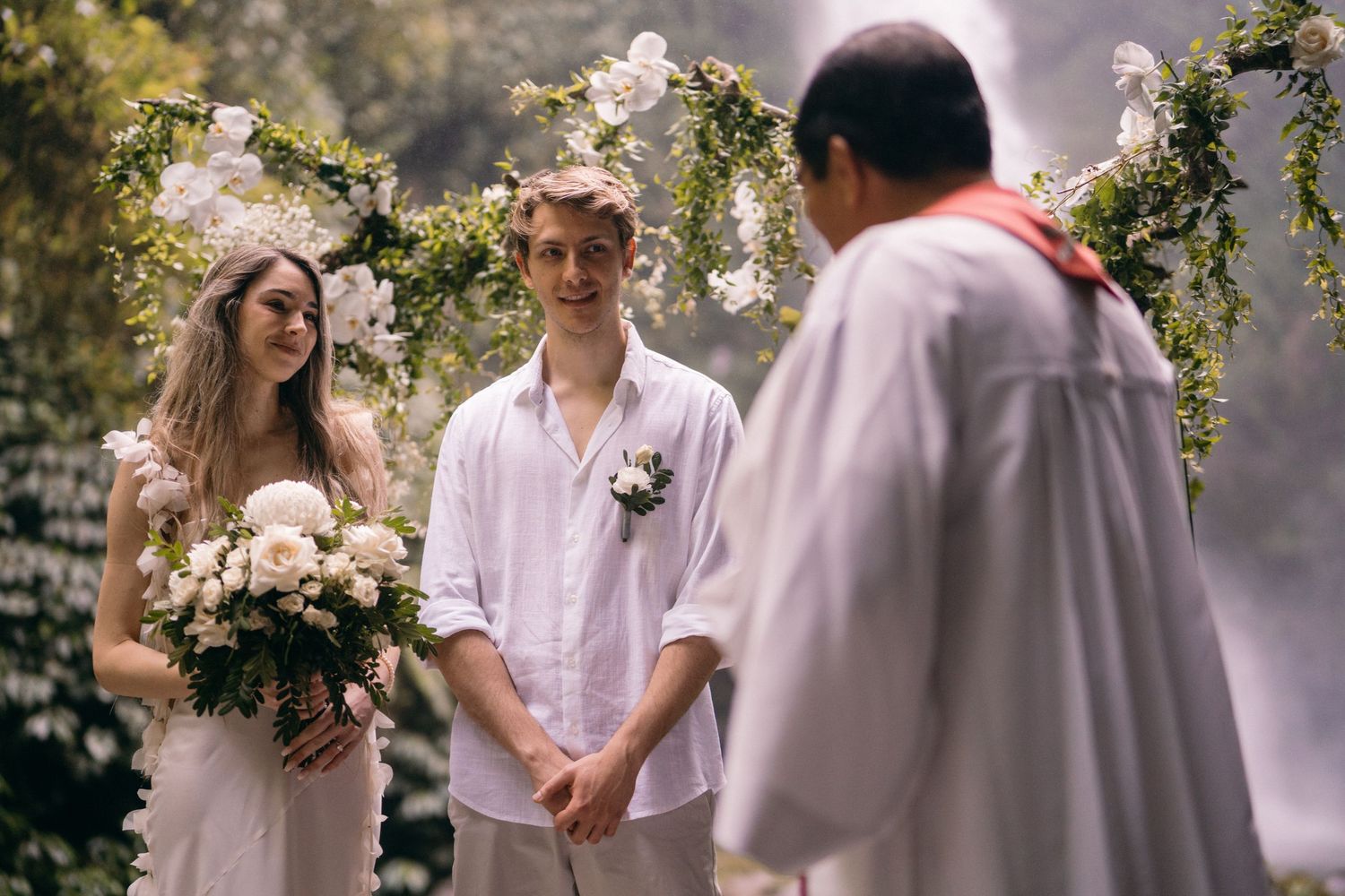 A romantic outdoor wedding ceremony with soft pink cherry blossoms and natural lighting creating a dreamy atmosphere.