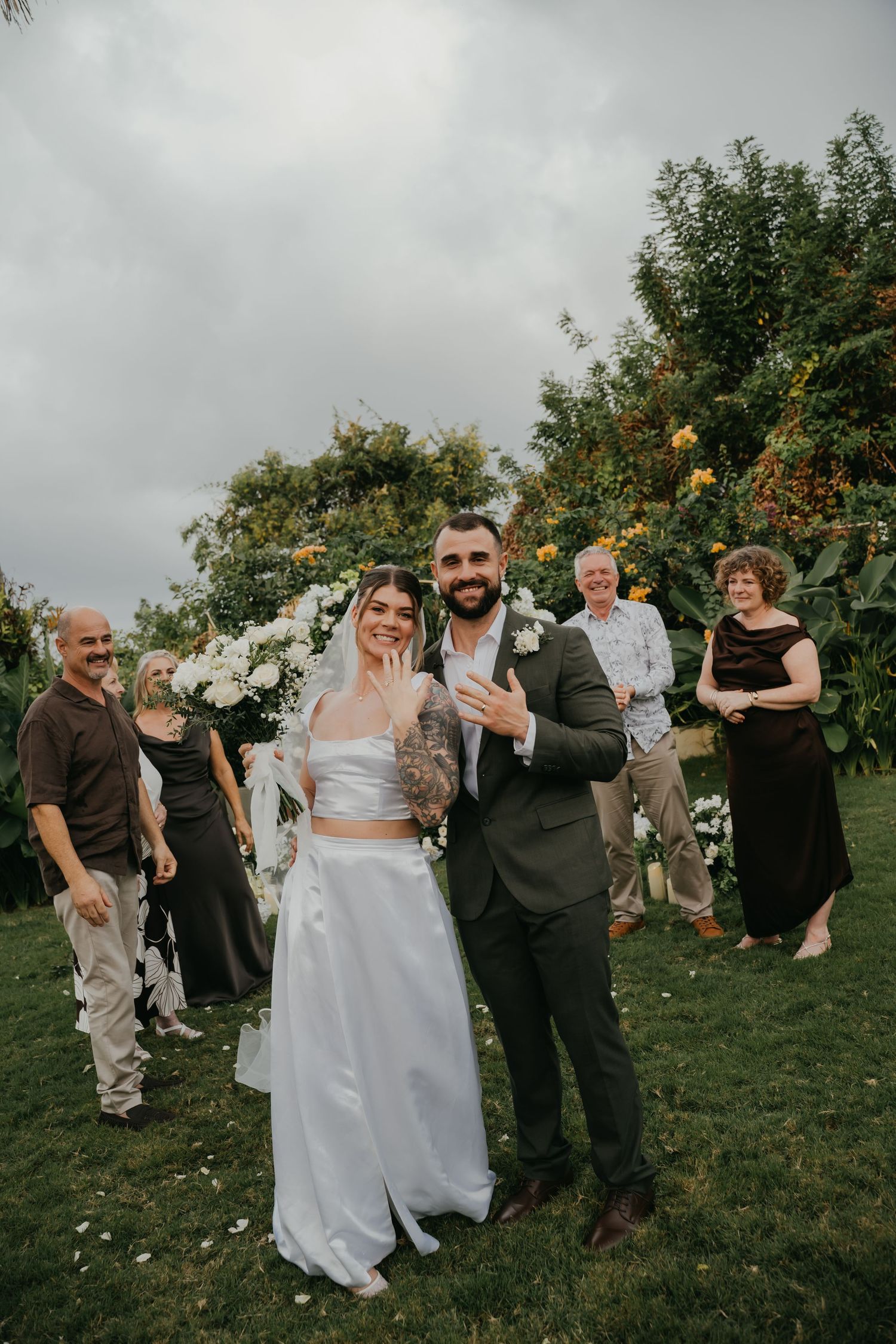 Newlyweds celebrate with family after outdoor garden wedding ceremony.