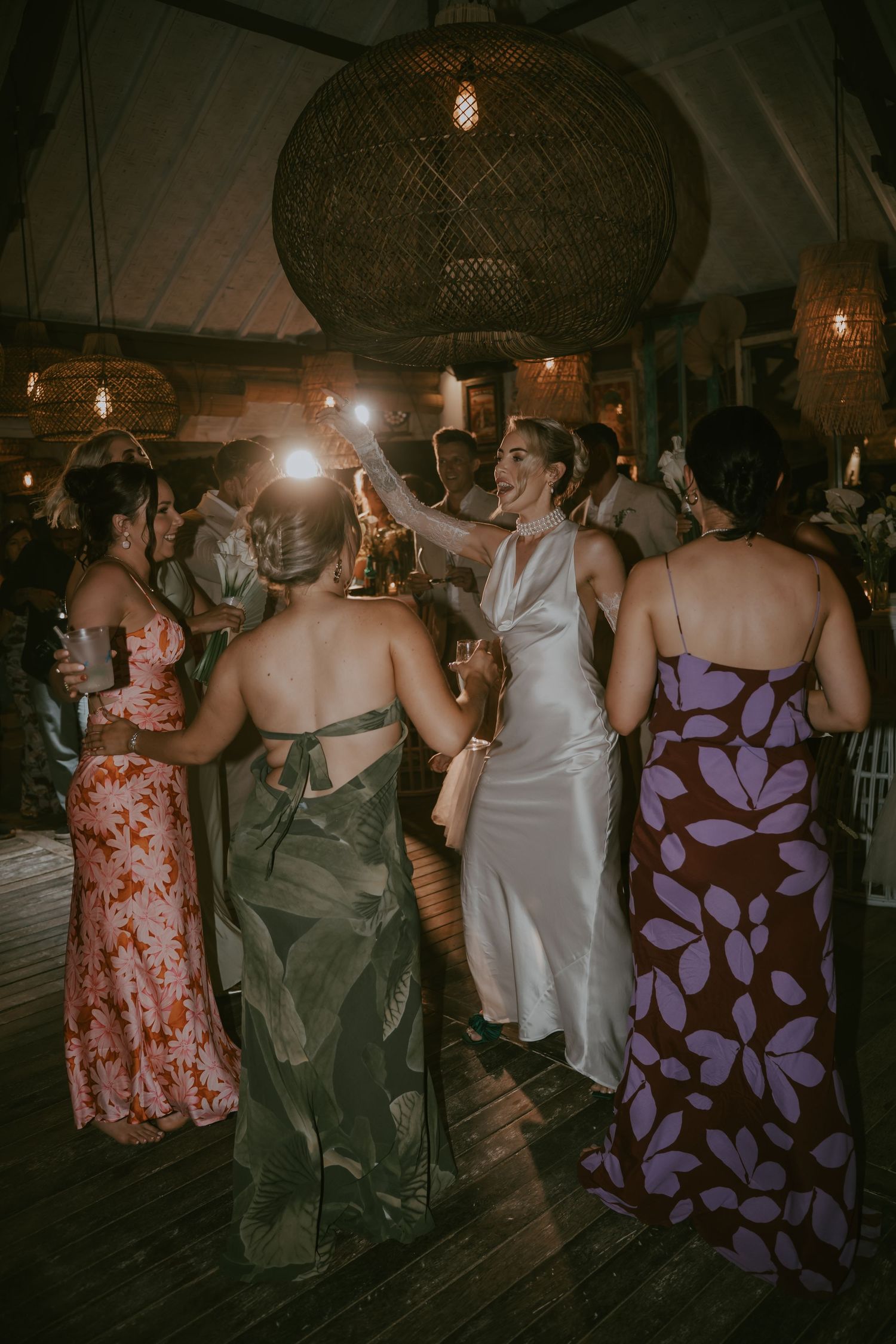 Wedding reception dance floor with guests in colorful dresses enjoying the celebration.
