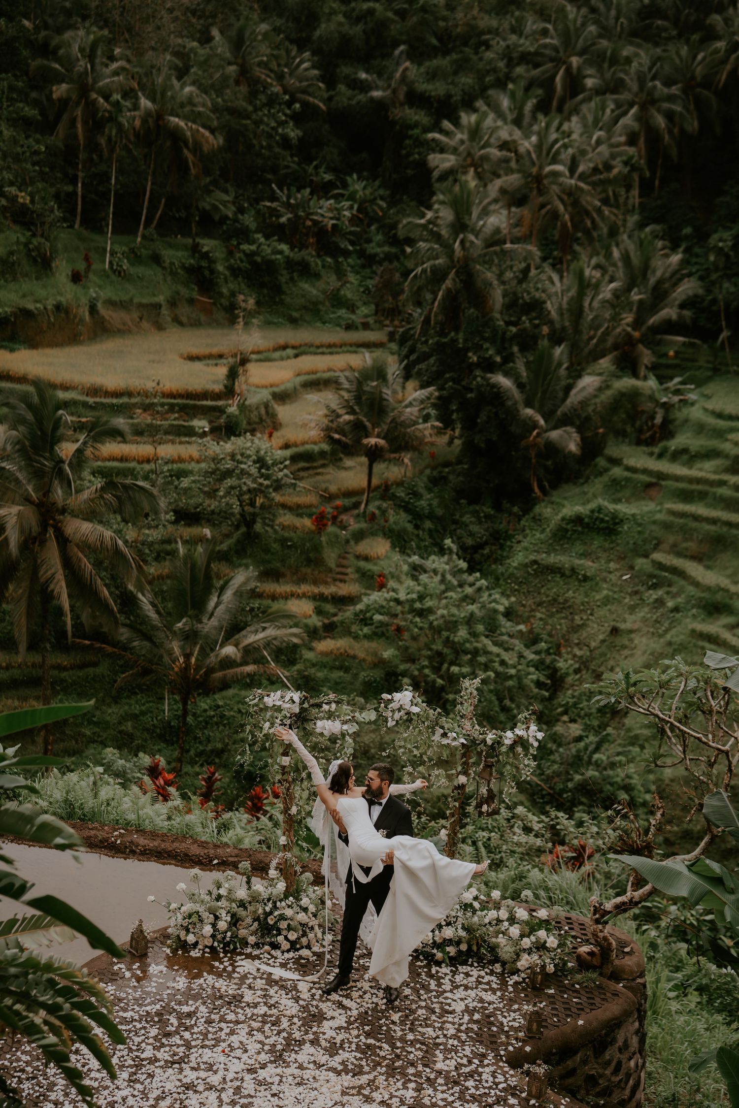 A couple celebrates their wedding among lush tropical greenery and terraced rice fields in Bali.