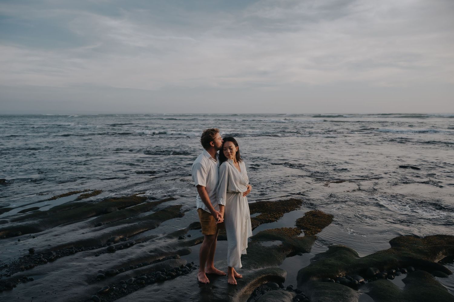 A series of romantic beach photos showing a couple walking along the shoreline at sunset with waves crashing nearby.