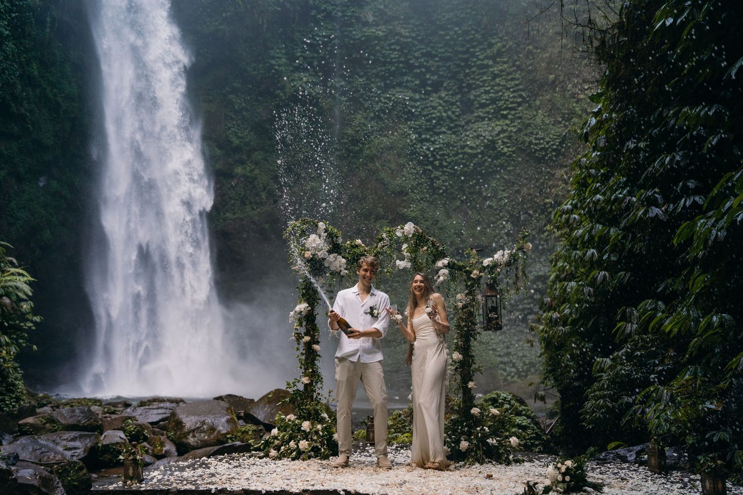 A series of eight connected photos showing people enjoying views of a majestic tropical waterfall in a lush forest setting.