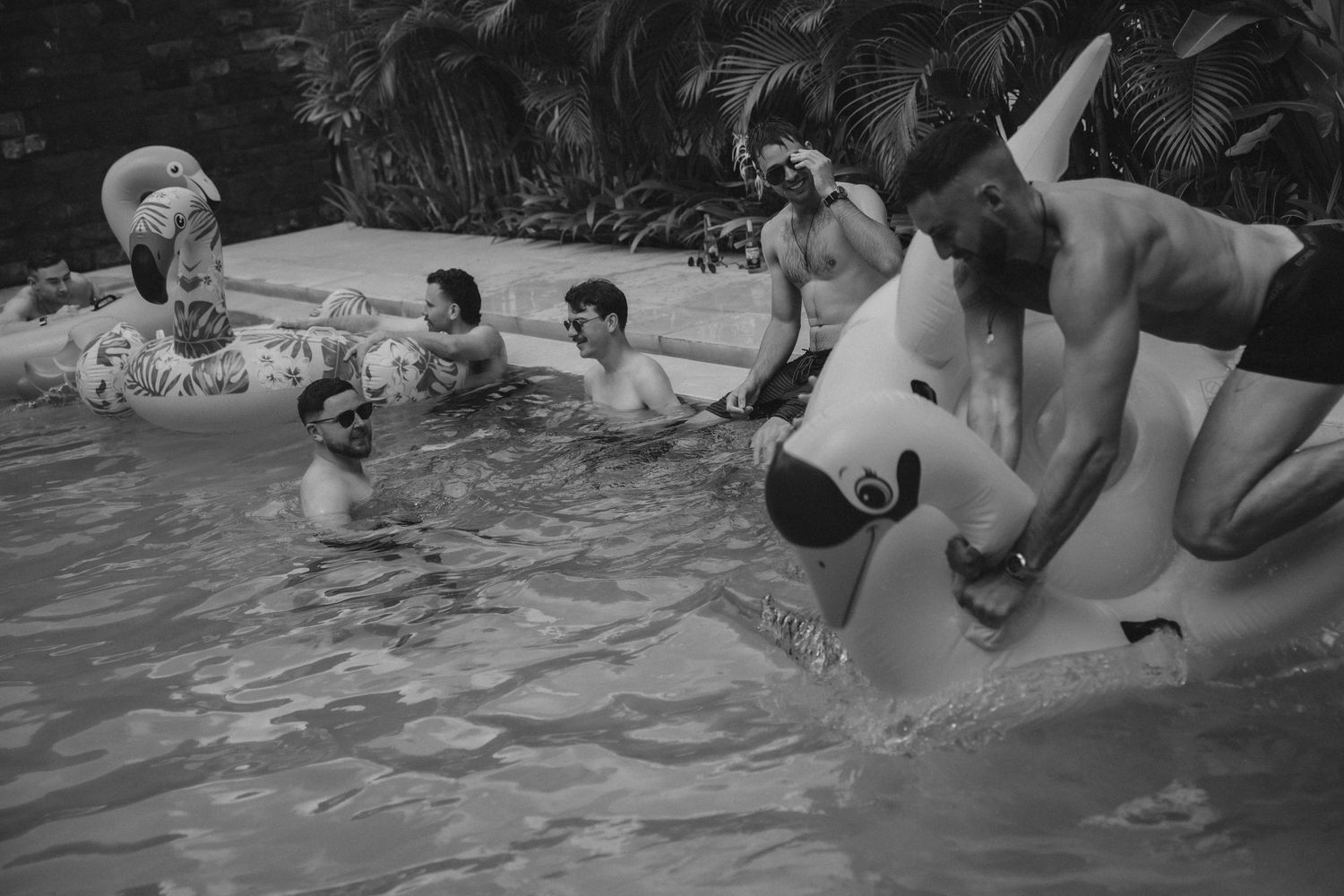 Group of friends relaxing in a pool during a summer gathering.