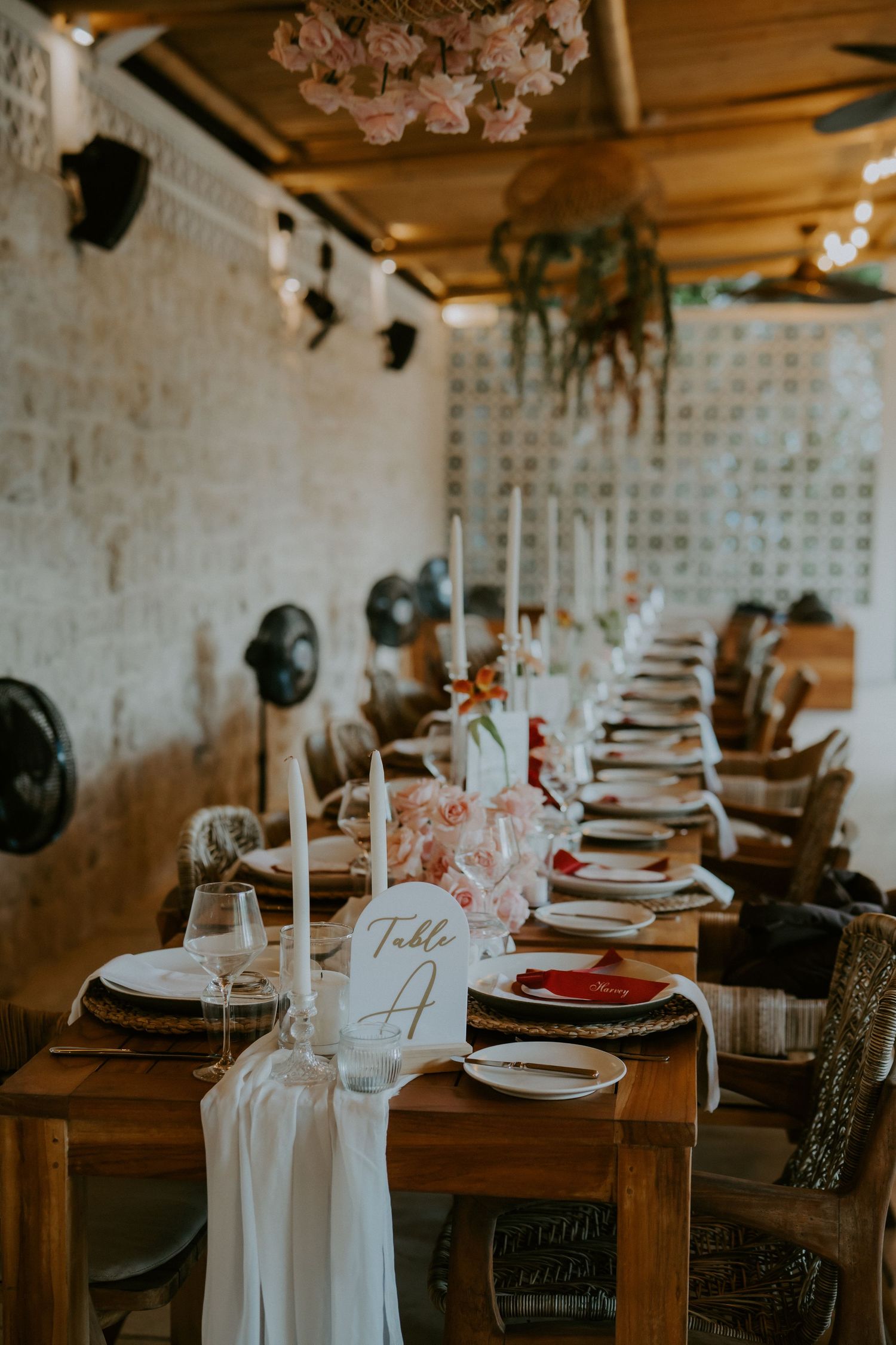 Elegant wedding reception table set with white linens, pink florals, and Table A sign.