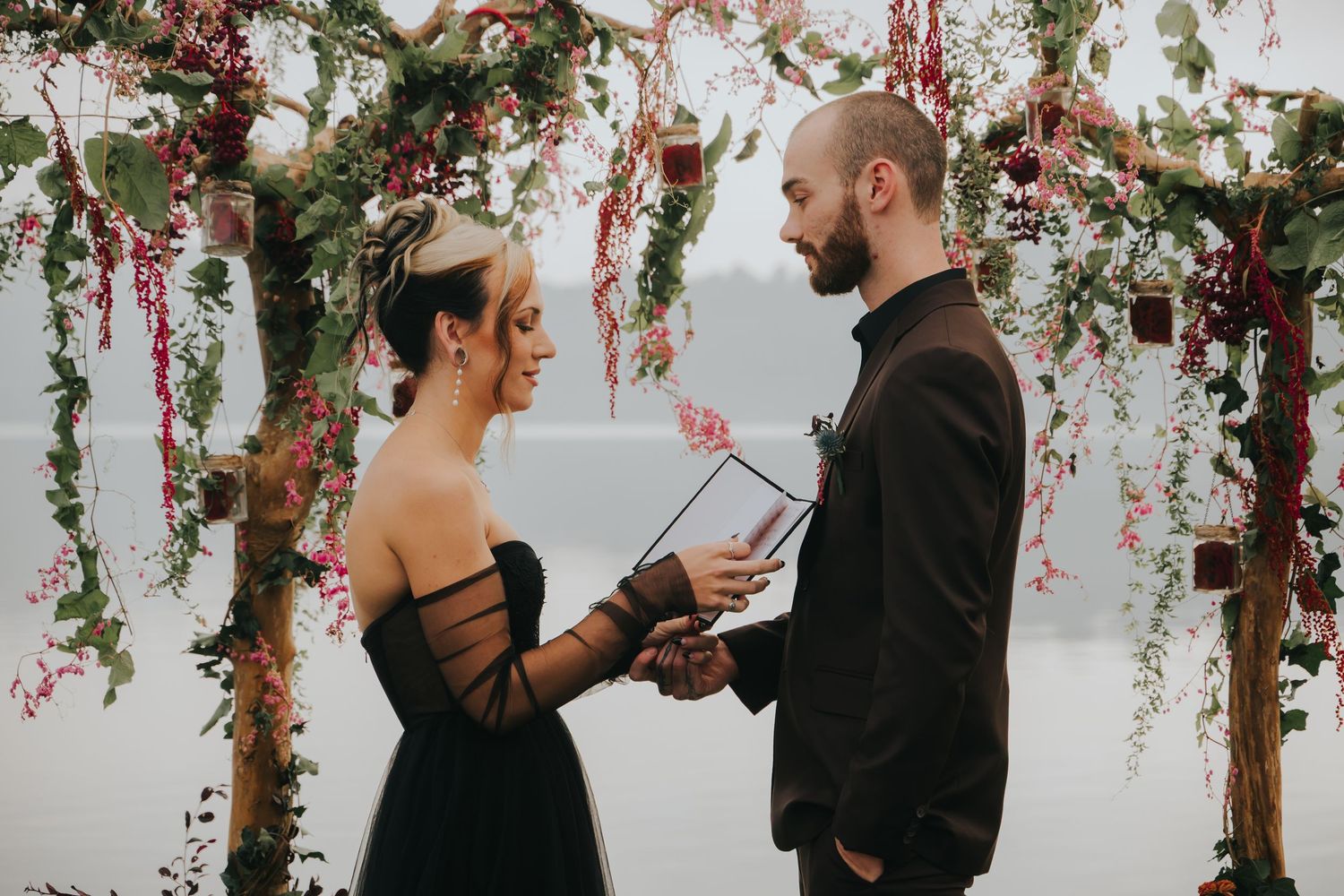 A romantic ceremony under floral archways with hanging pink and white blooms.