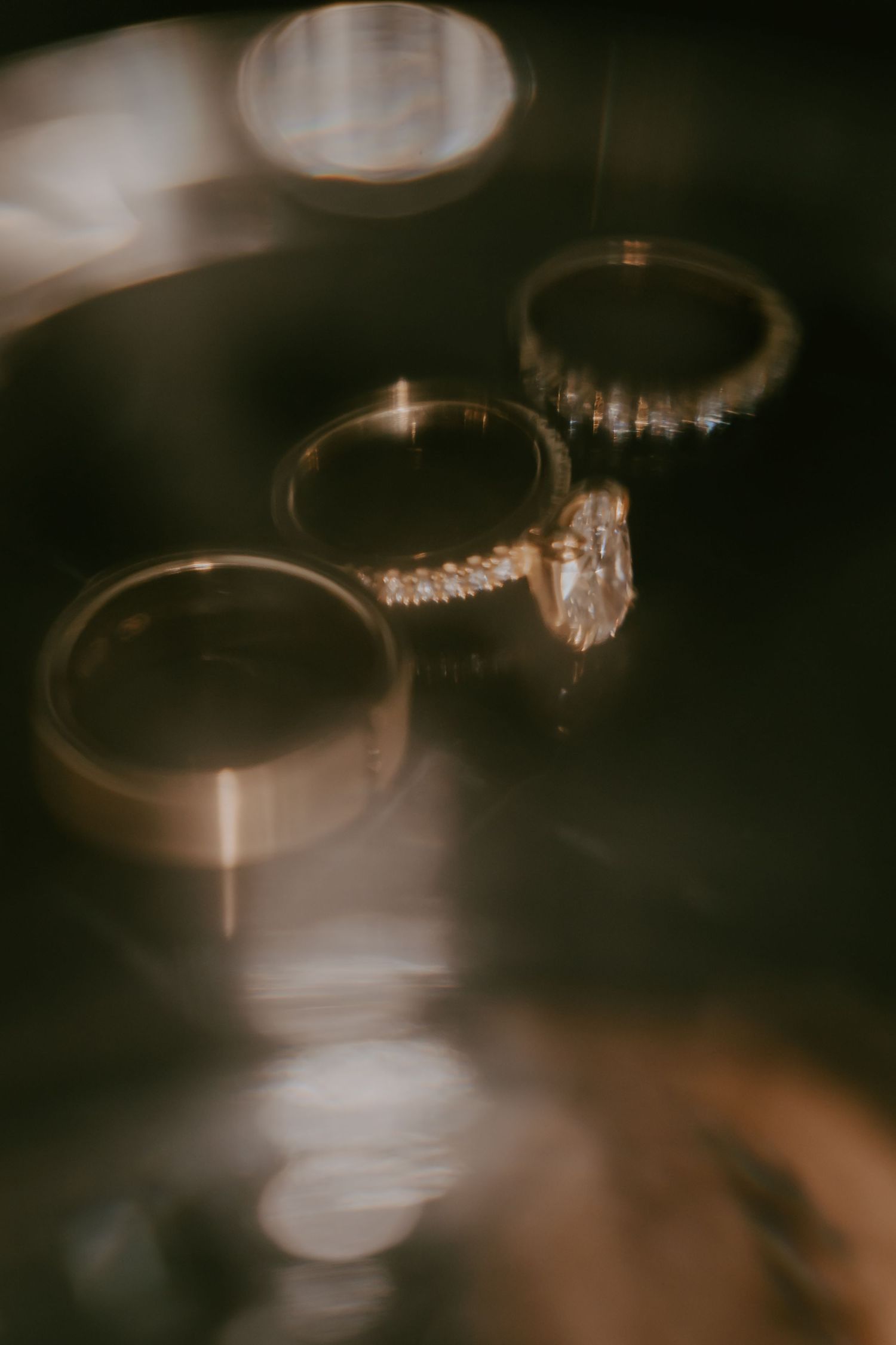 Artistic close-up of wedding rings with bokeh lighting effects.