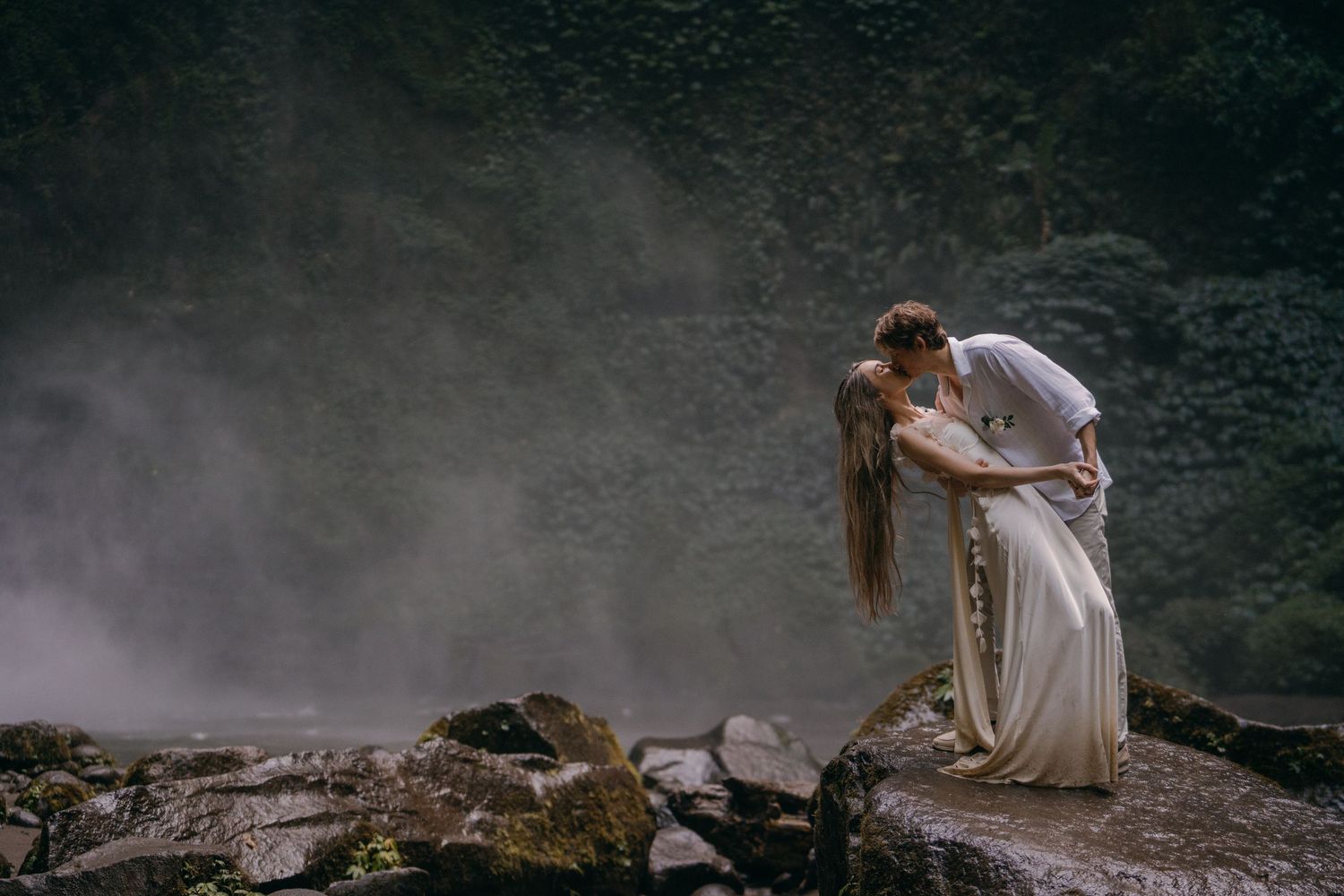 A dramatic scene from a historical movie showing figures in white robes walking through misty mountain terrain.