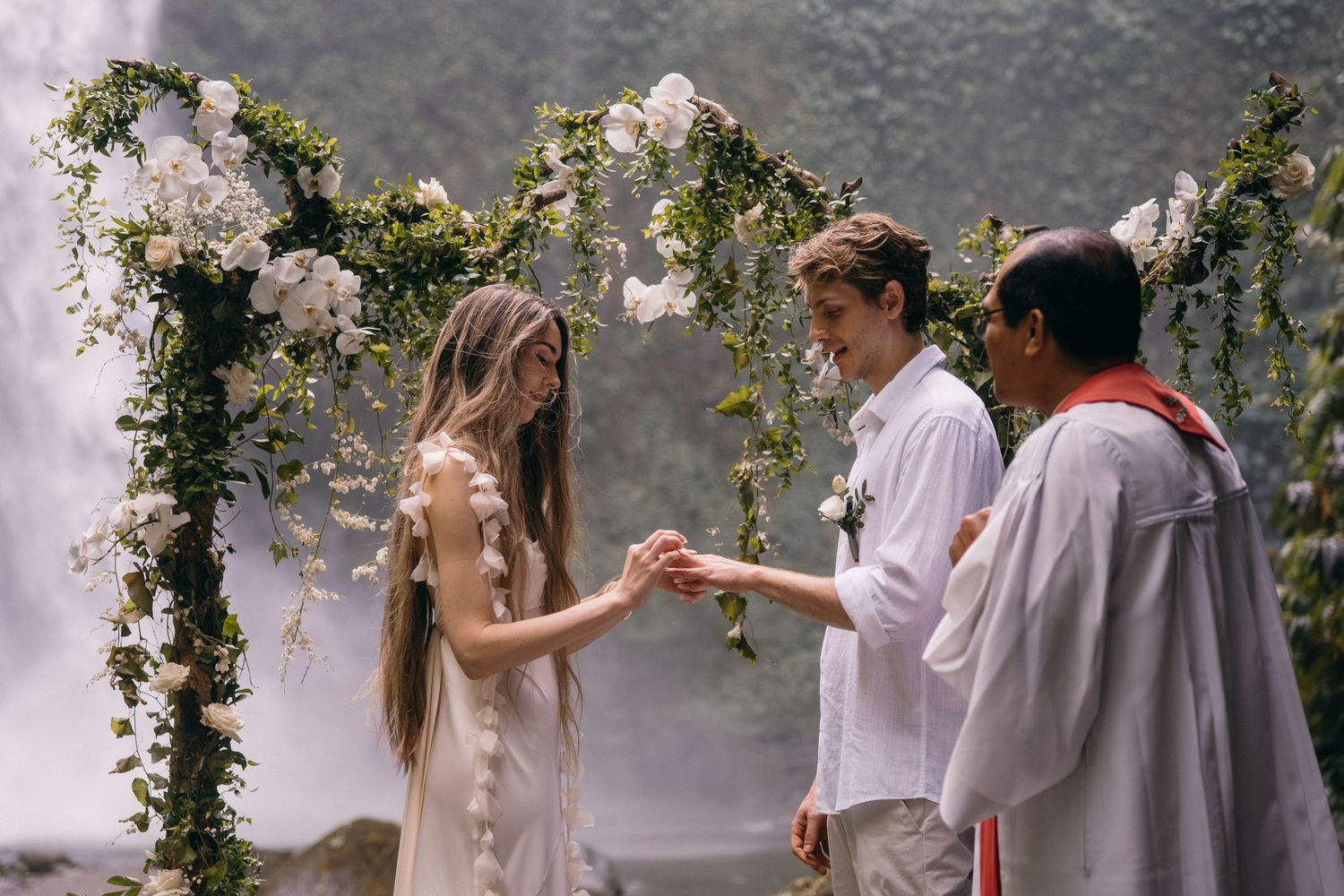 A sequence of romantic wedding photos showing couples in white attire embracing under floral decorations and greenery.