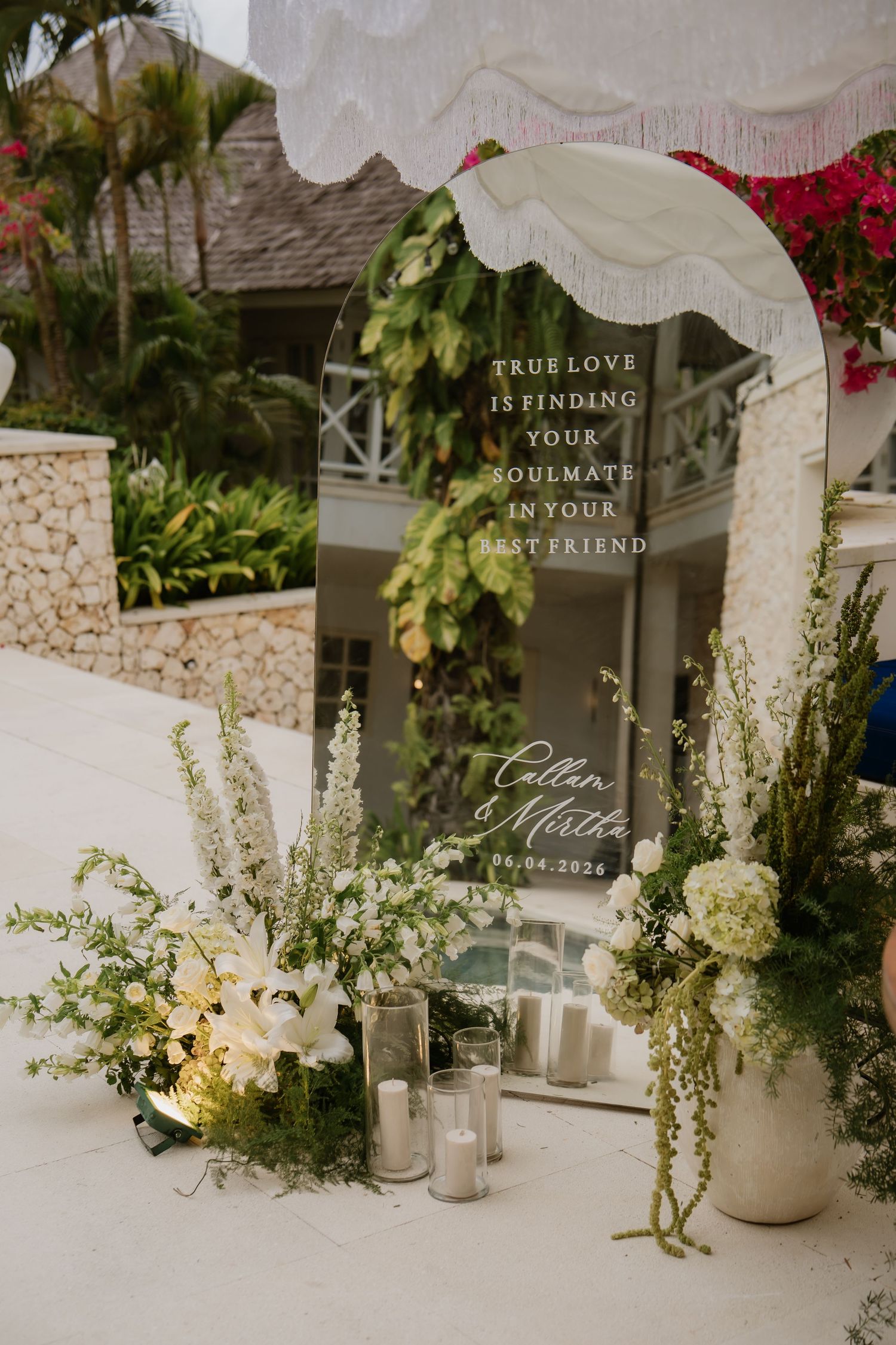 Elegant wedding welcome mirror sign with white floral arrangements and greenery reading True Love is Finding Your Soulmate.