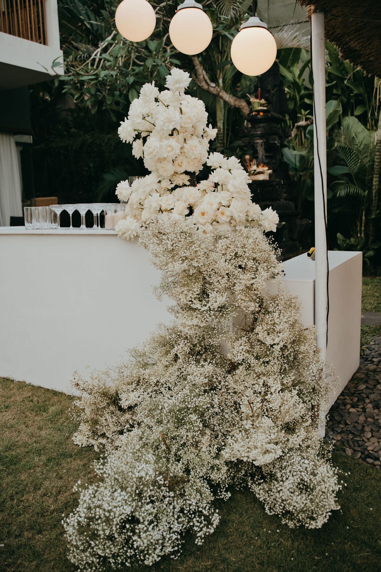 Elegant wedding bar decorated with cascading white roses and baby's breath floral arrangement.