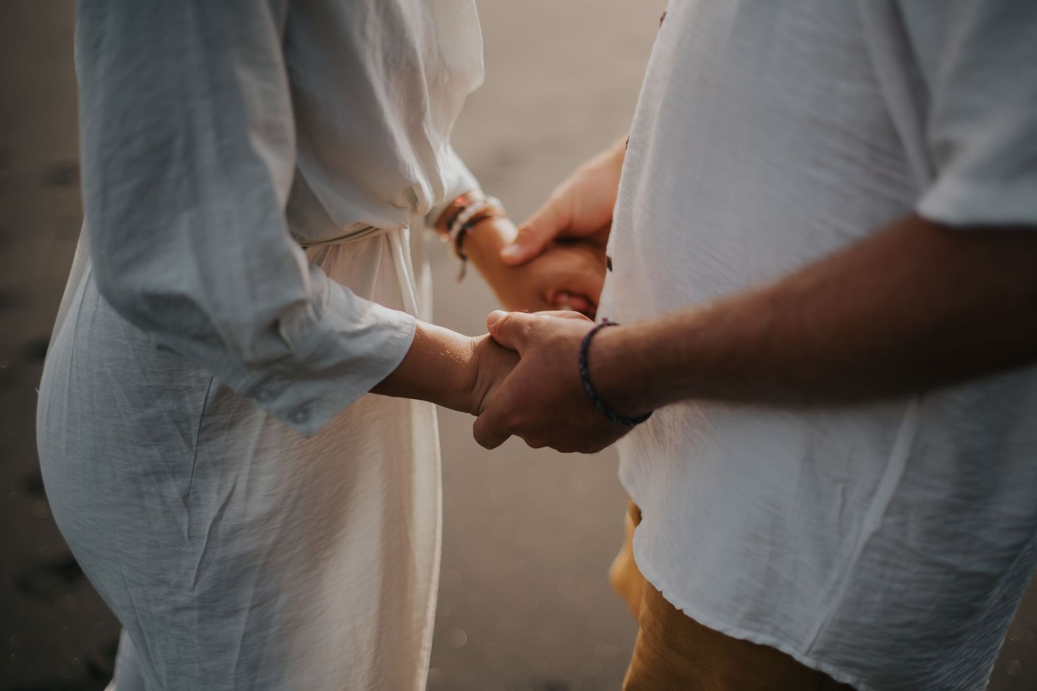 Close-up view of hands exchanging wedding rings during an intimate ceremony.