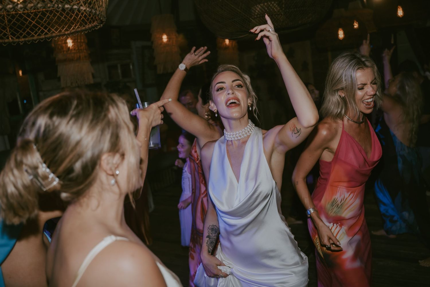 Energetic dance floor moment with guests celebrating at wedding reception.