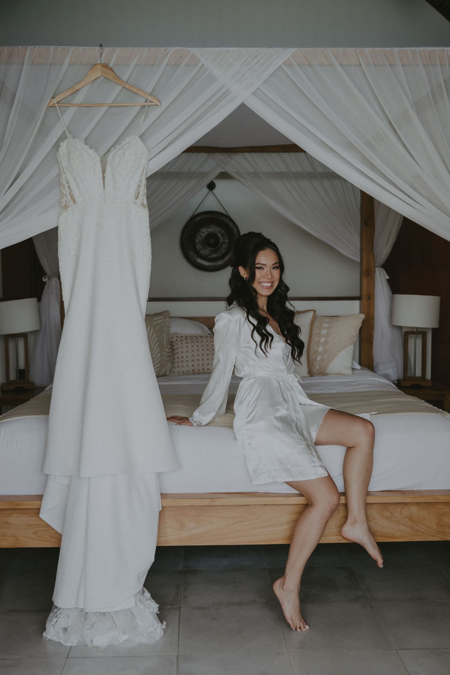 Artistic series of shots showing a wedding dress and white canopy bed in a minimalist room.