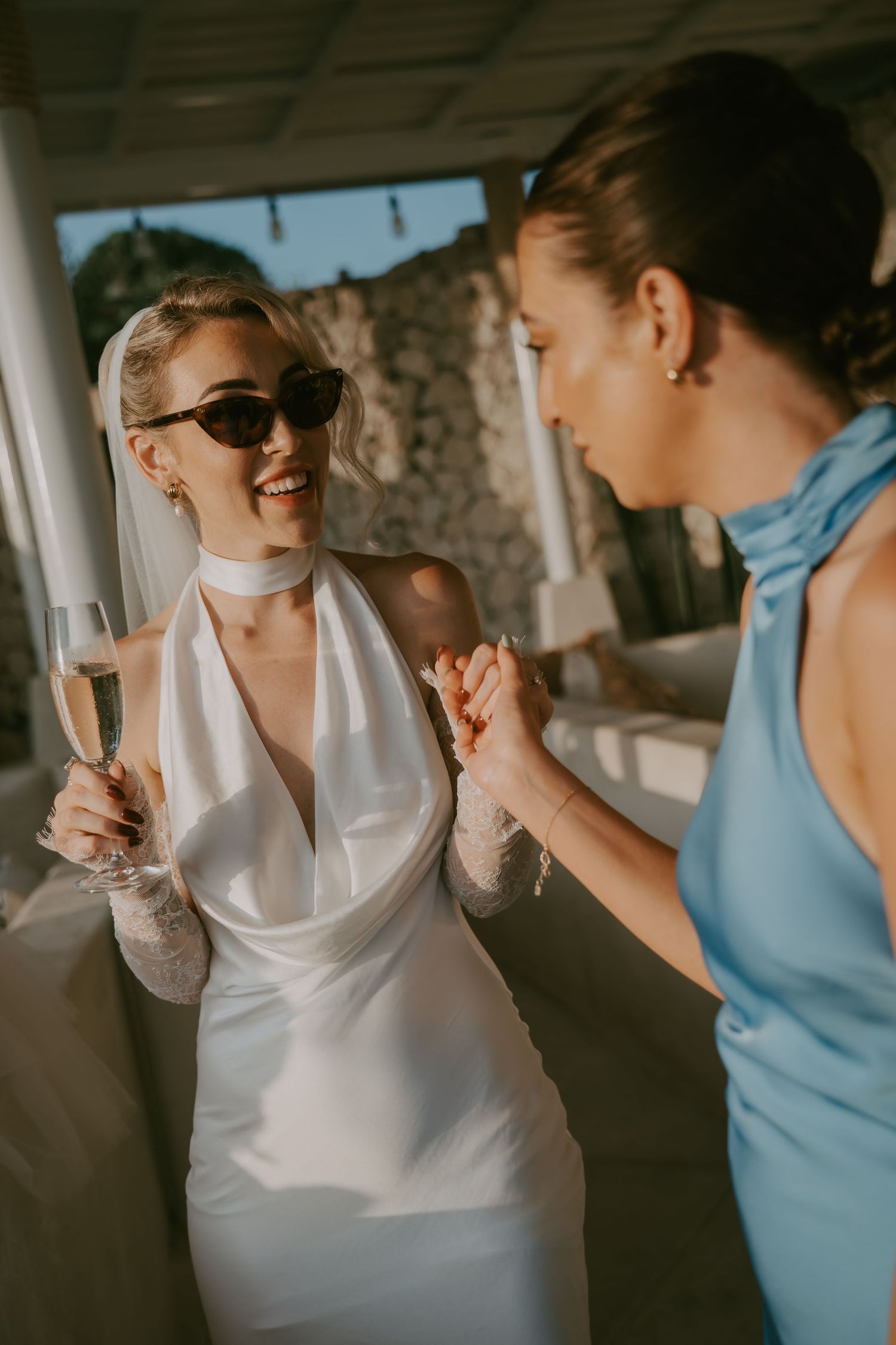 Wedding celebration with guests in white and blue attire sharing joyful moments.