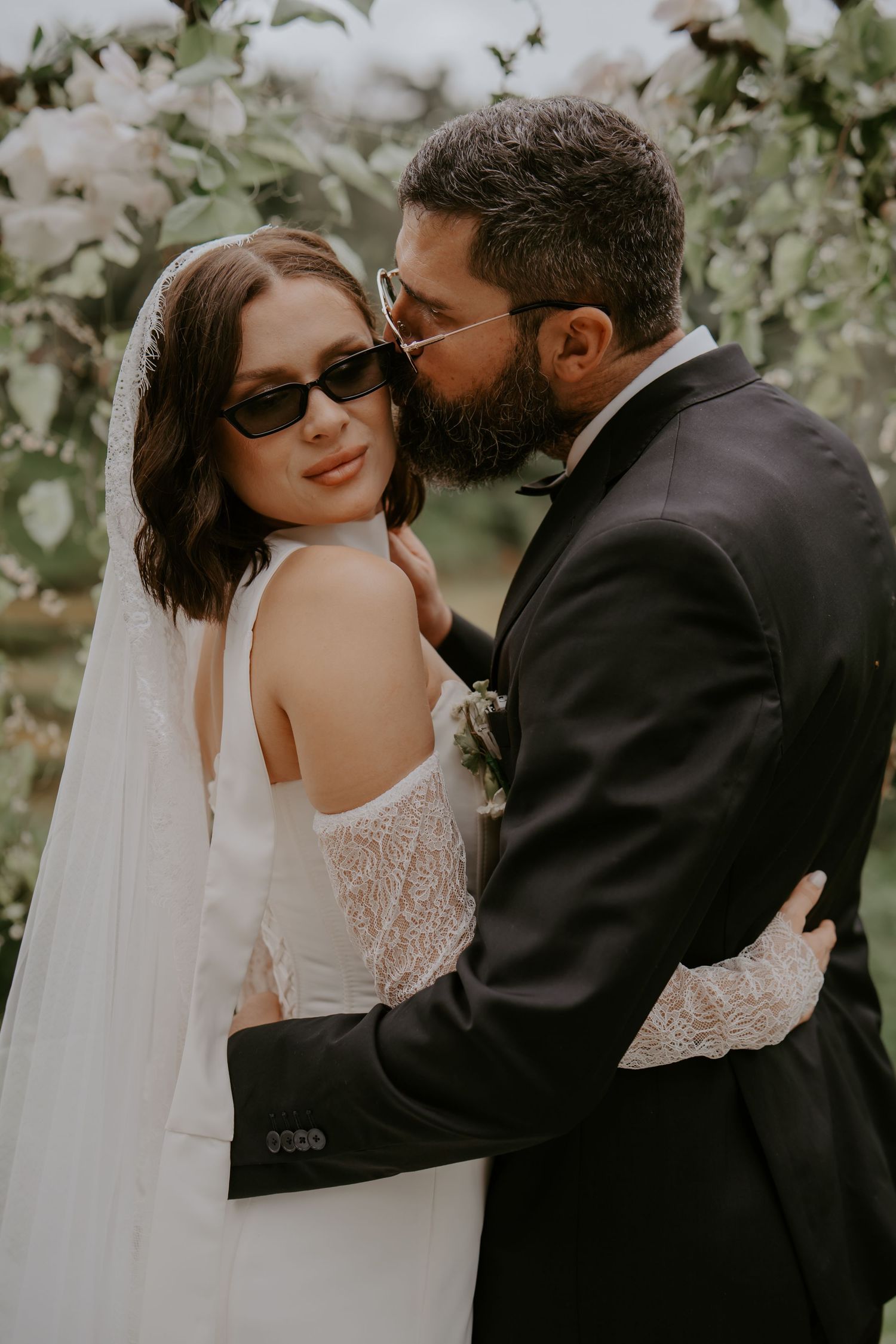 A romantic wedding photoshoot showing tender moments between a couple in a garden setting.