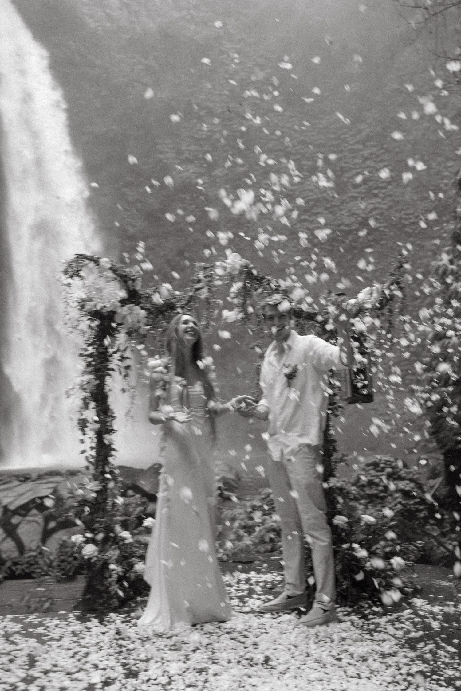 A black and white photo sequence shows a wedding celebration with falling confetti and flower petals in an outdoor setting.