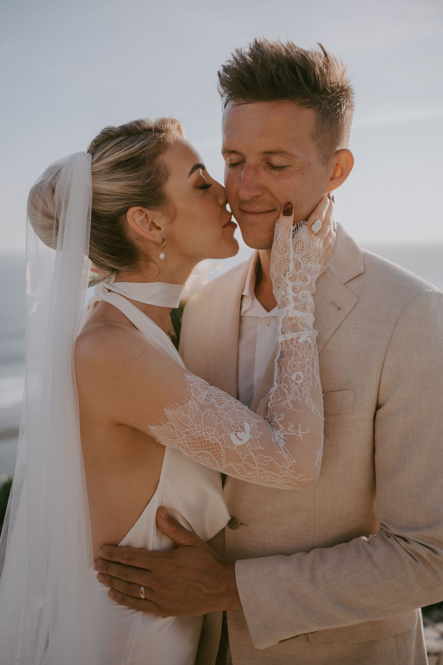 Romantic wedding portraits captured against soft coastal lighting.