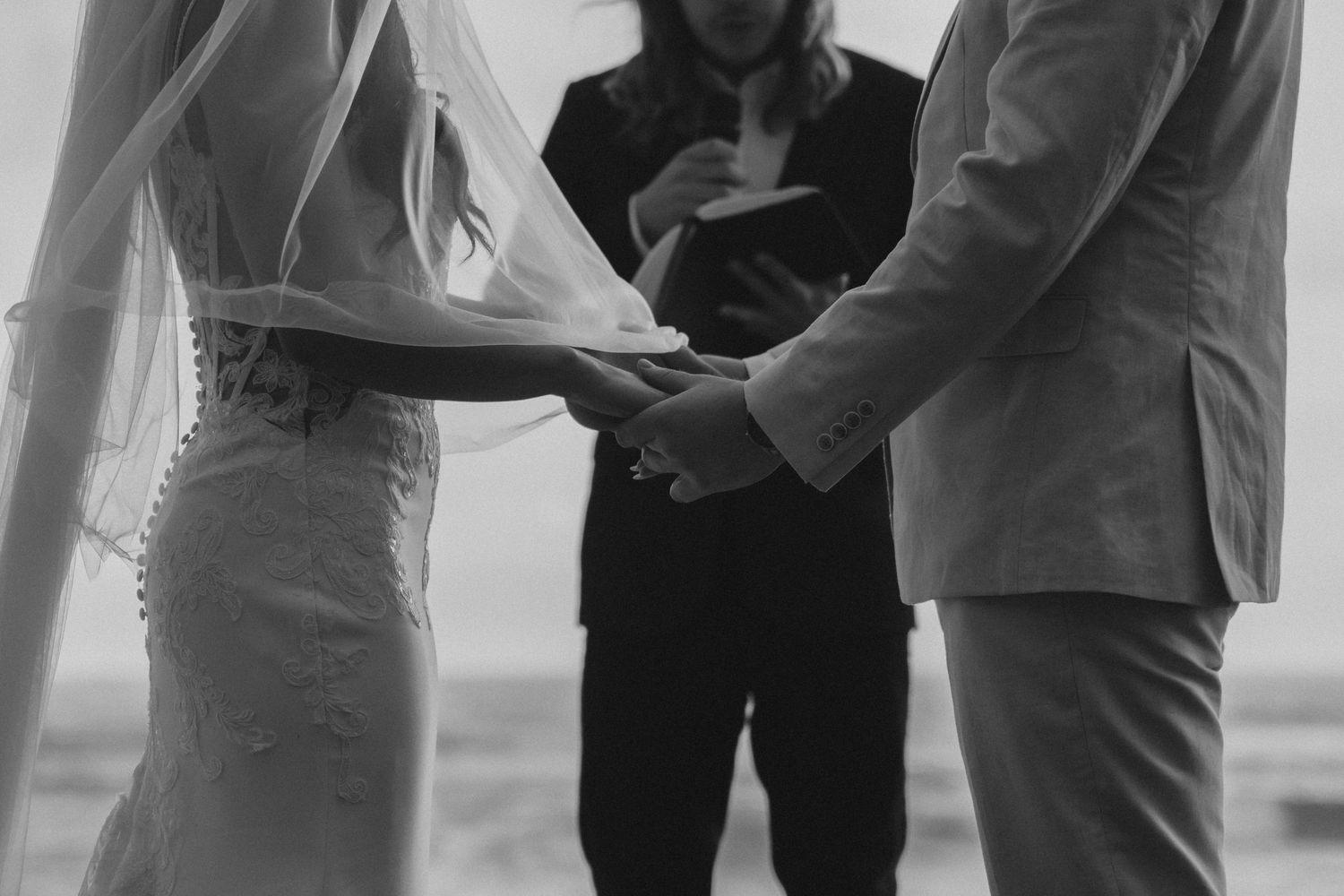 Black and white image showing wedding ceremony attendees gathered in formal attire.