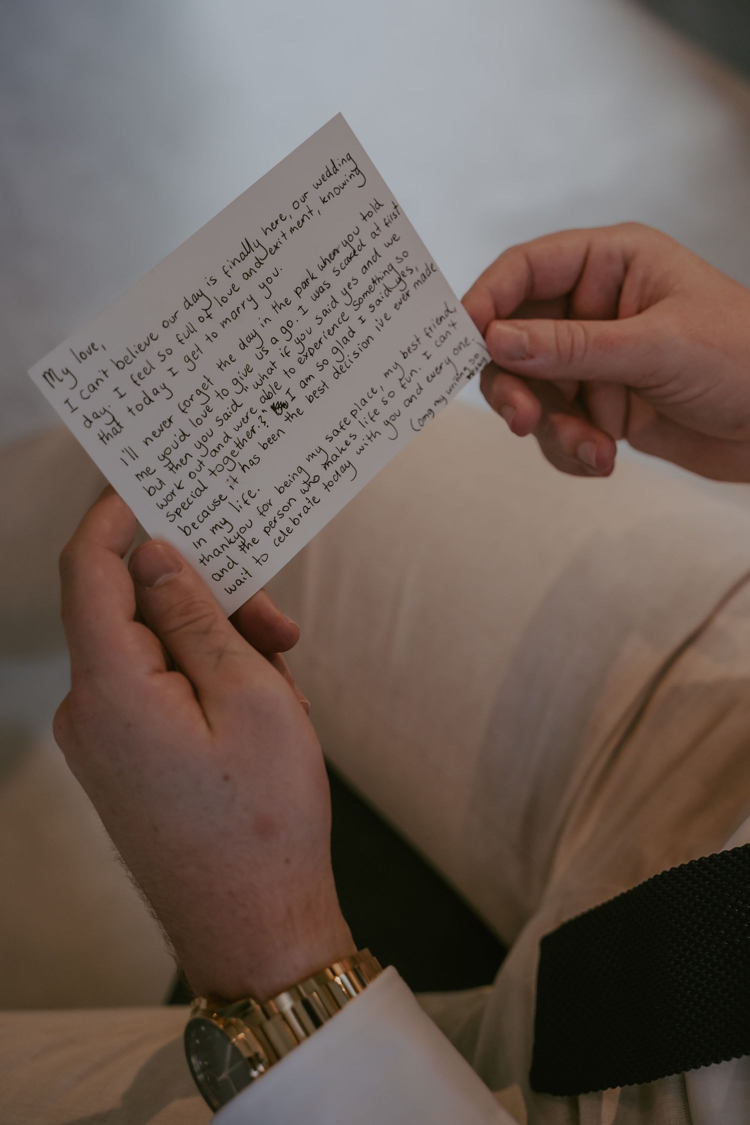 Hands holding and reading handwritten text on white index cards in a sequence of connected images.